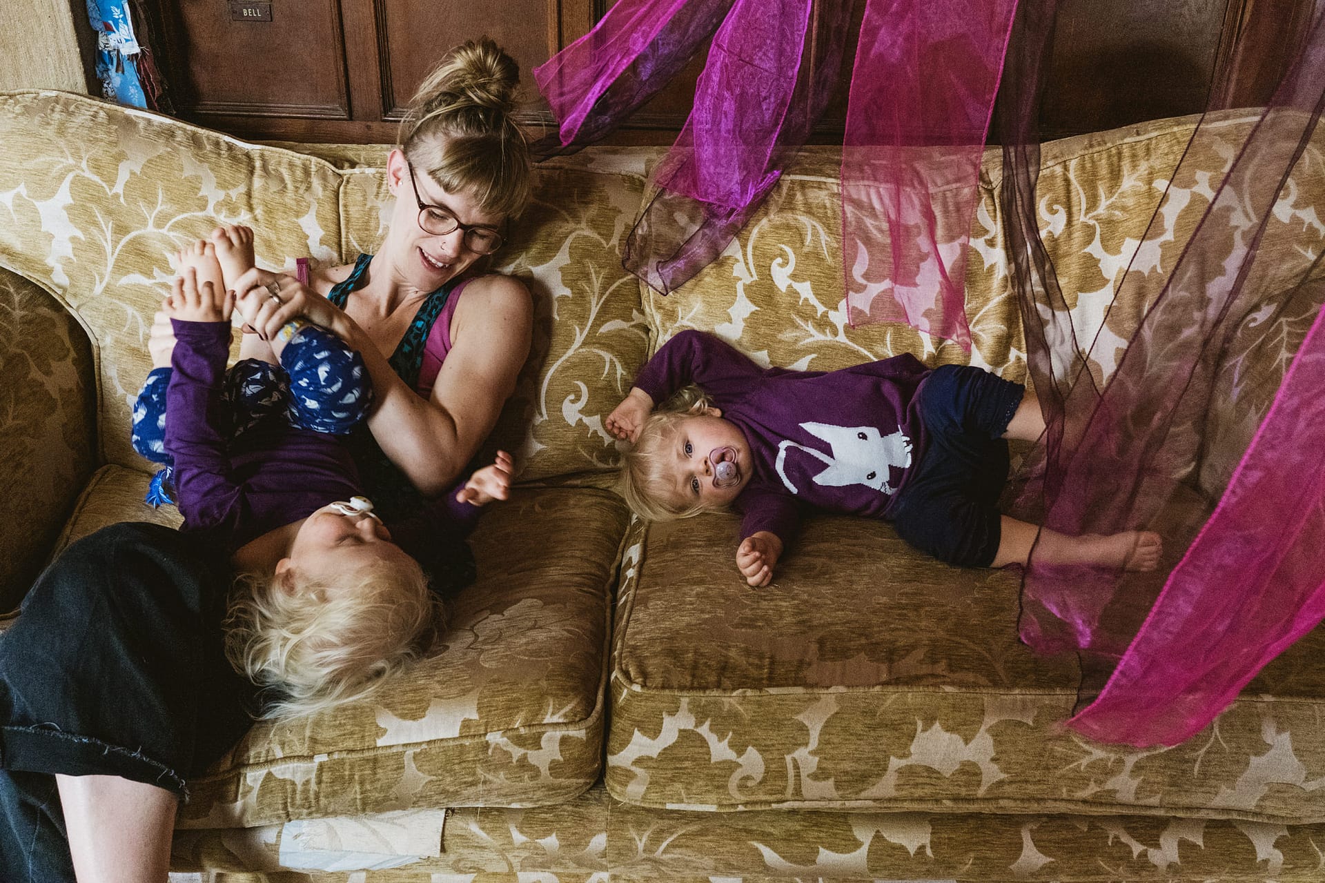 Mother playing with children on sofa