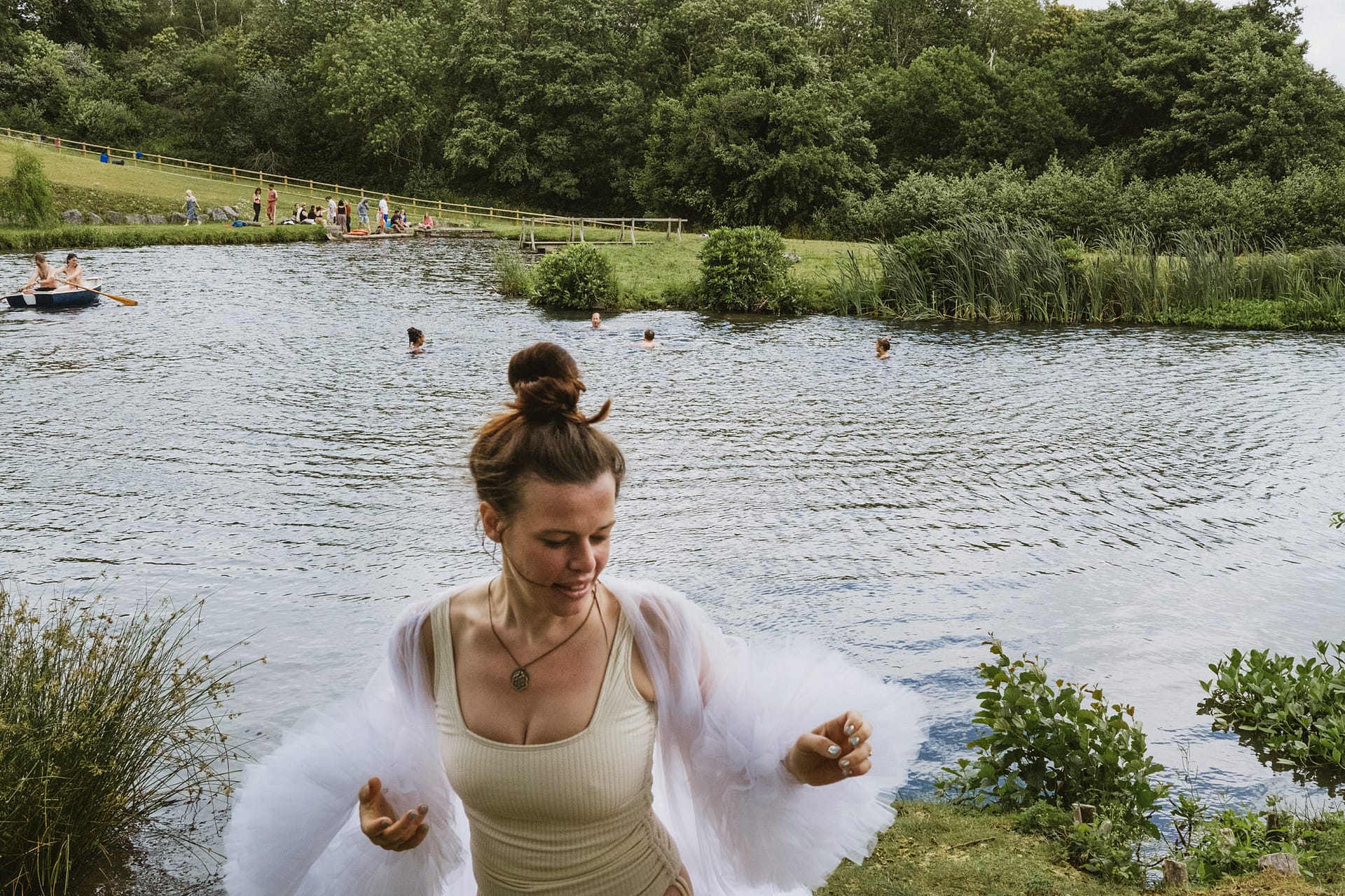People swim in a lake surrounded by trees.
