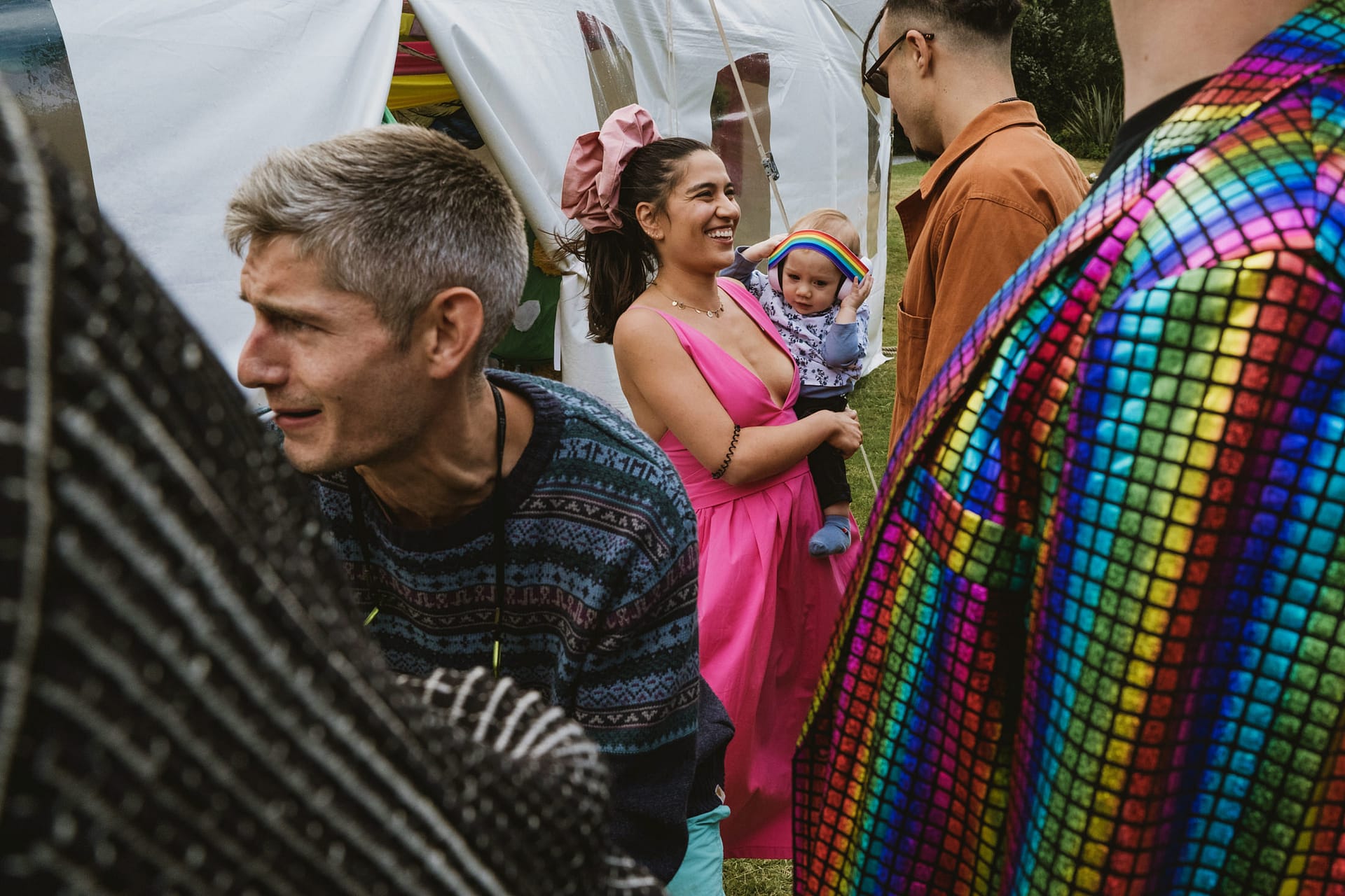 People at outdoor festival in colourful outfits.