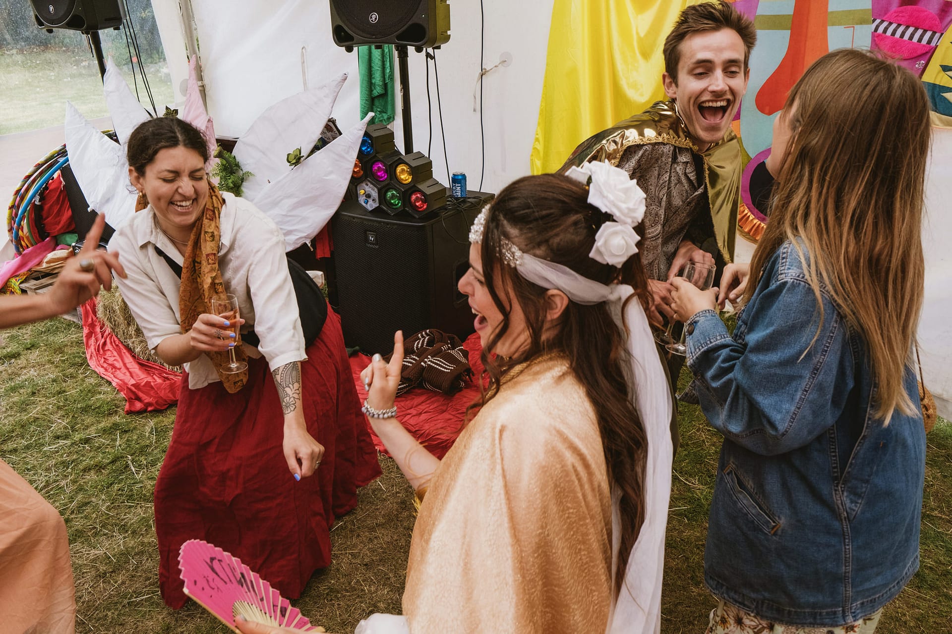 People in costumes laughing at outdoor party.