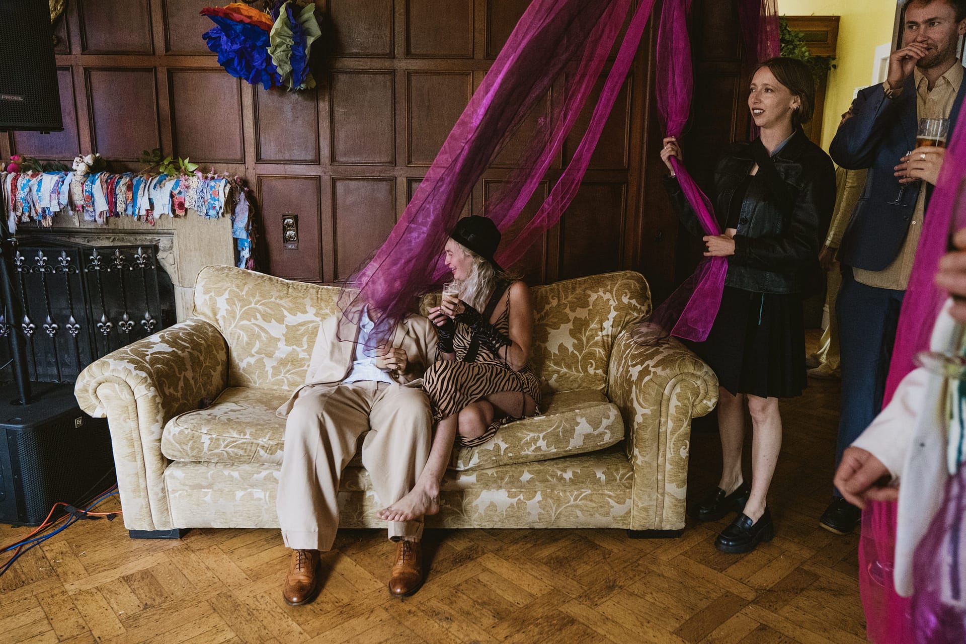 People sitting on a sofa with colourful decorations.