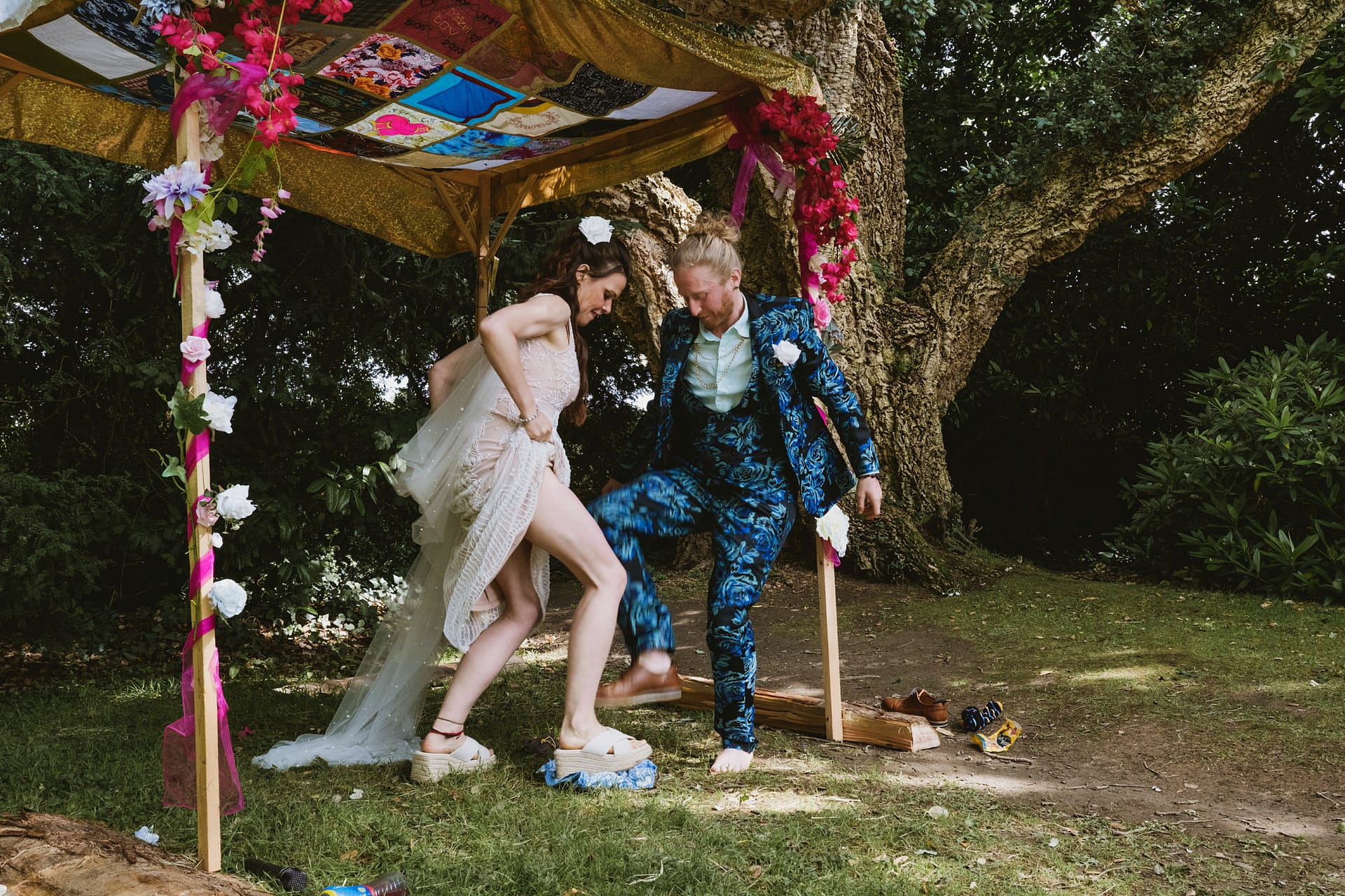 Couple jumping on glass at an outdoor Jewish wedding in a Colehayes Park wedding ceremony.