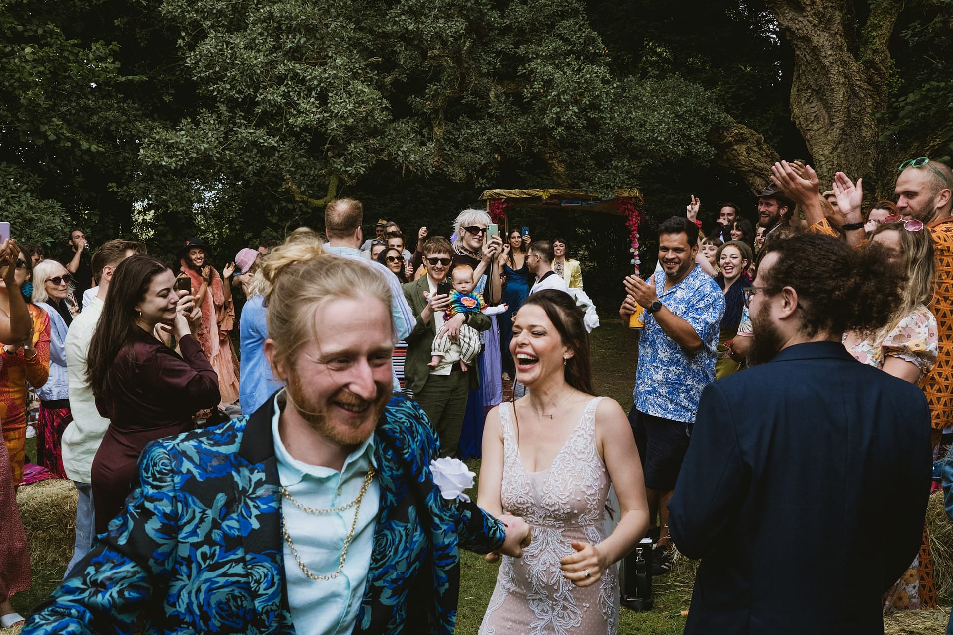 Colehayes Park Devon wedding photography. The bride and groom leave the ceremony. Wedding celebration with happy couple and cheering guests