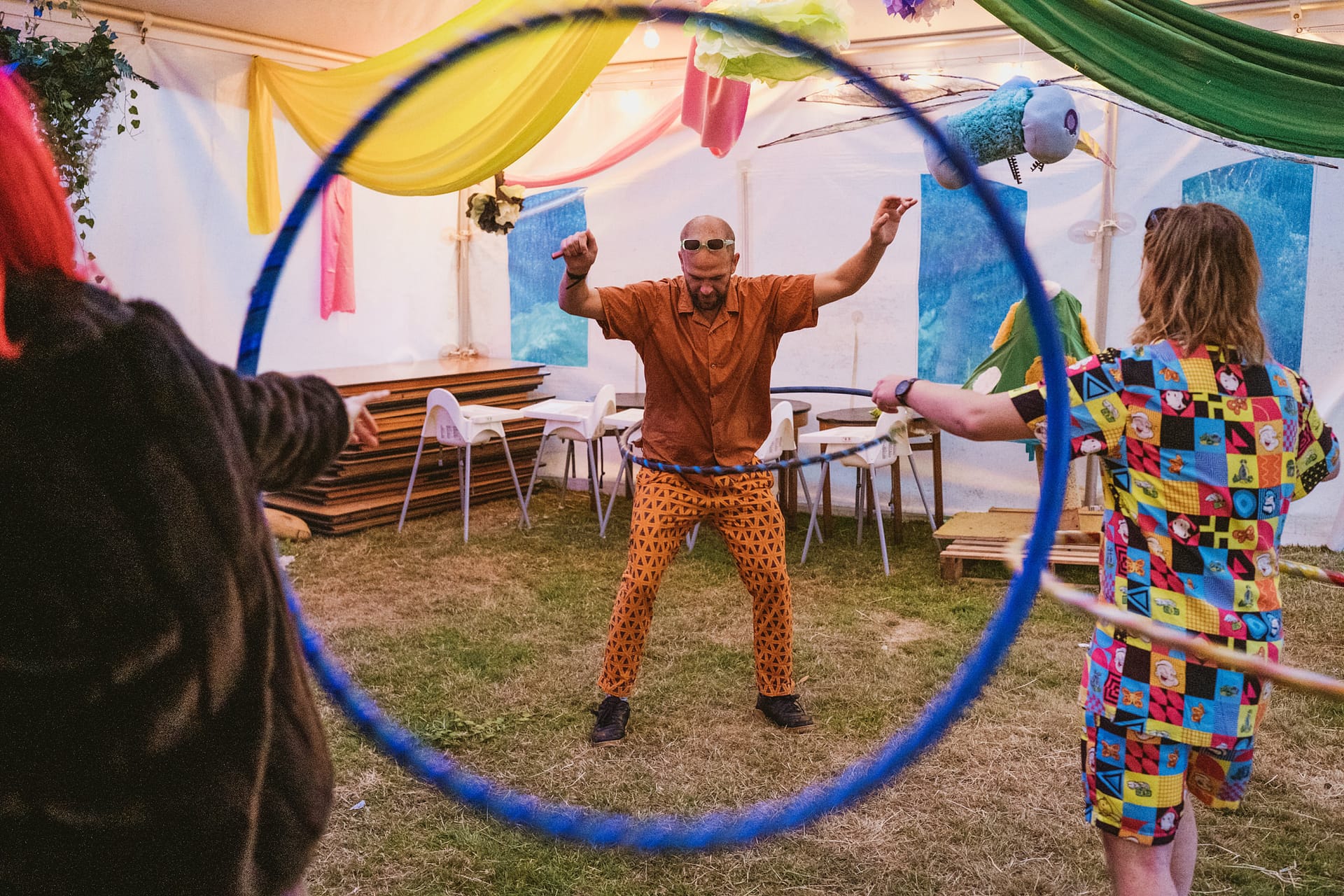 People playing with hula hoops at colourful party.