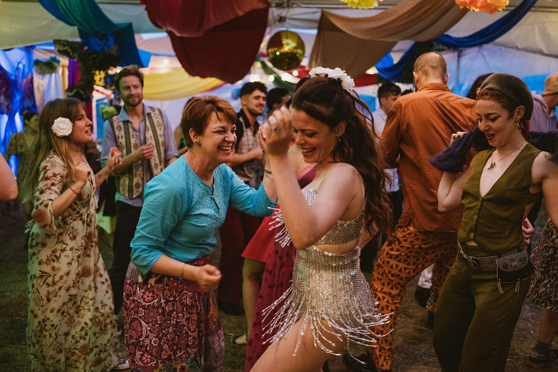 People dancing and celebrating at a colourful party.