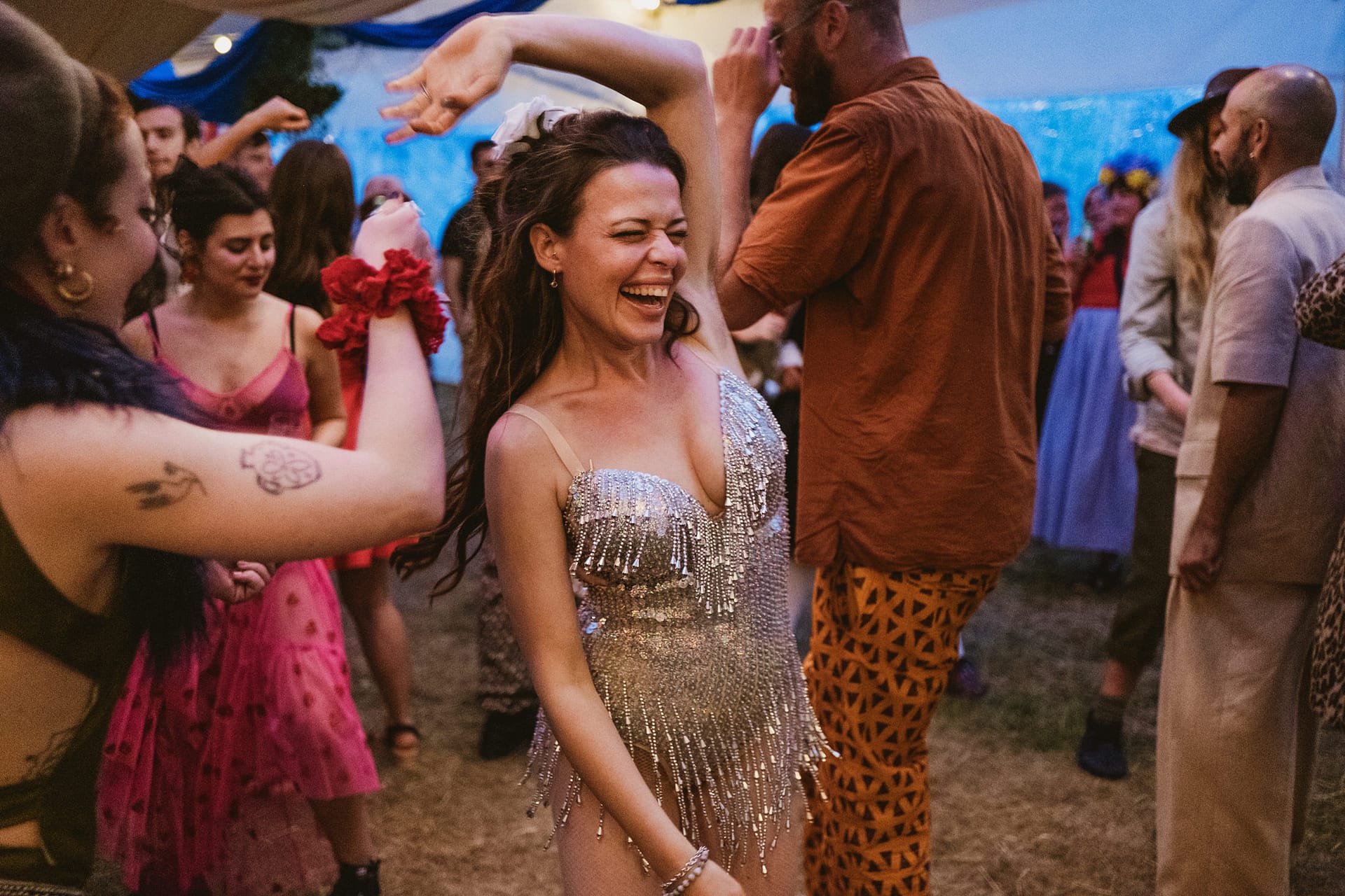 Woman in sparkly dress dancing at a party.