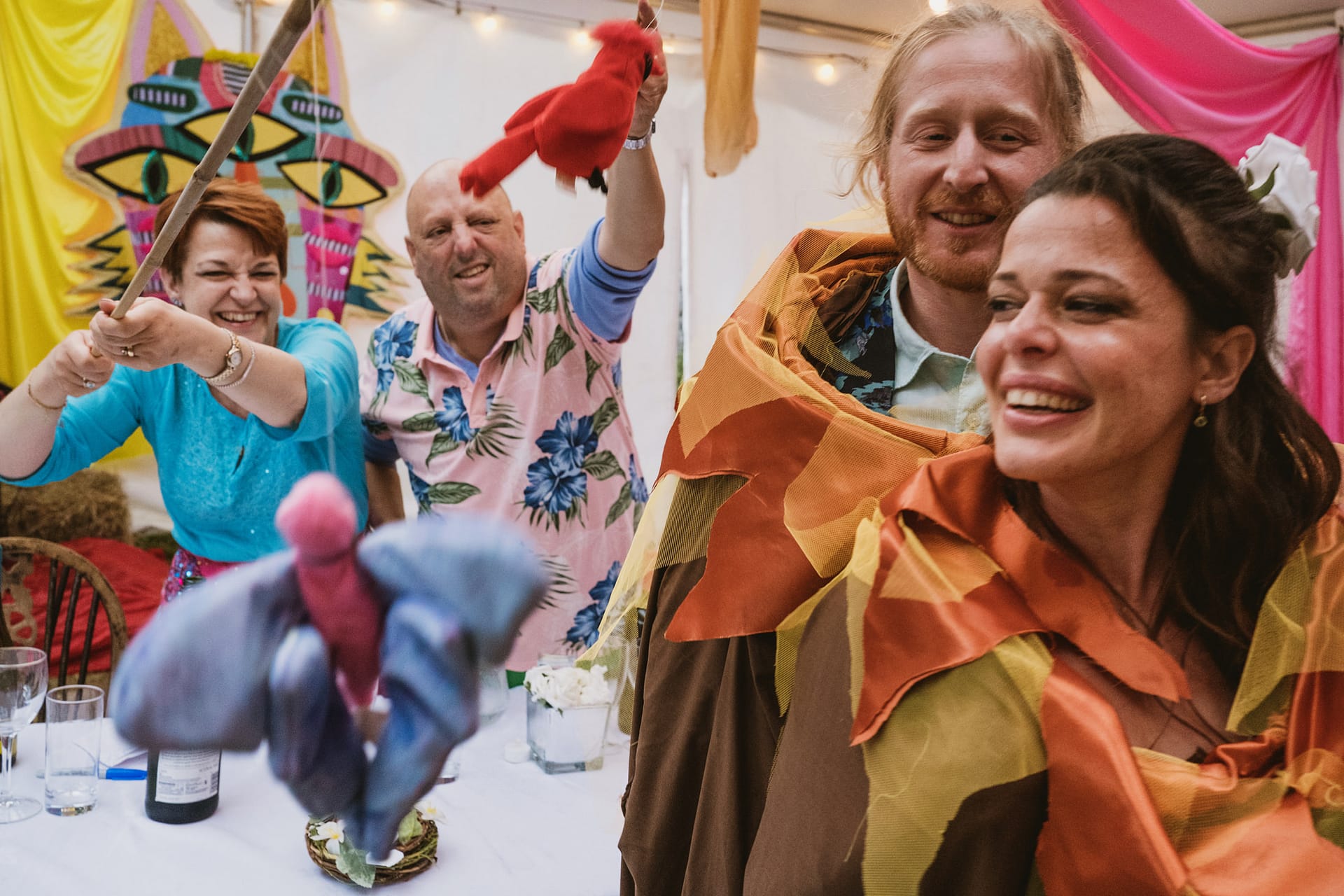 Adults enjoy a colourful puppet performance.