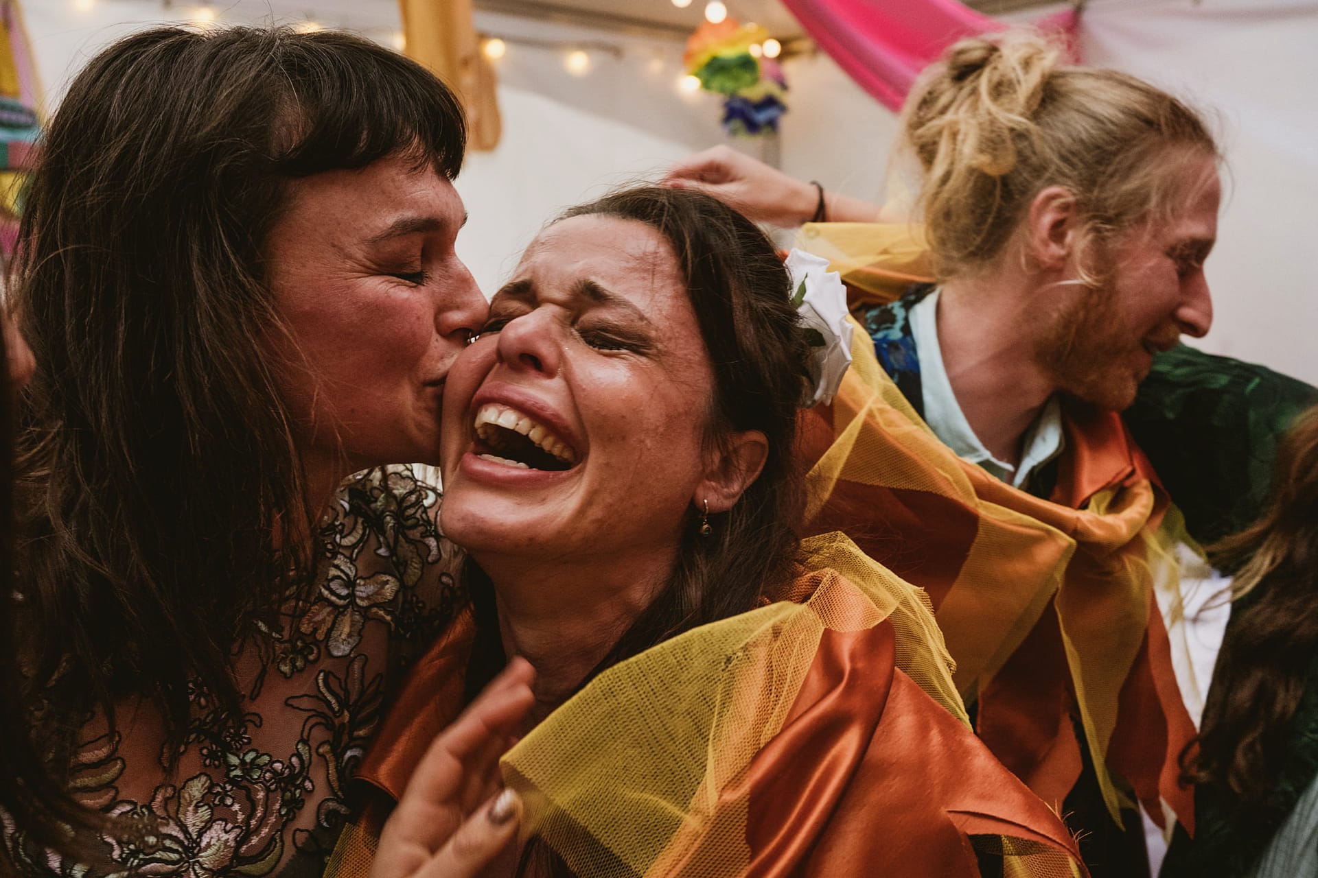 Women celebrating with laughter and kisses.