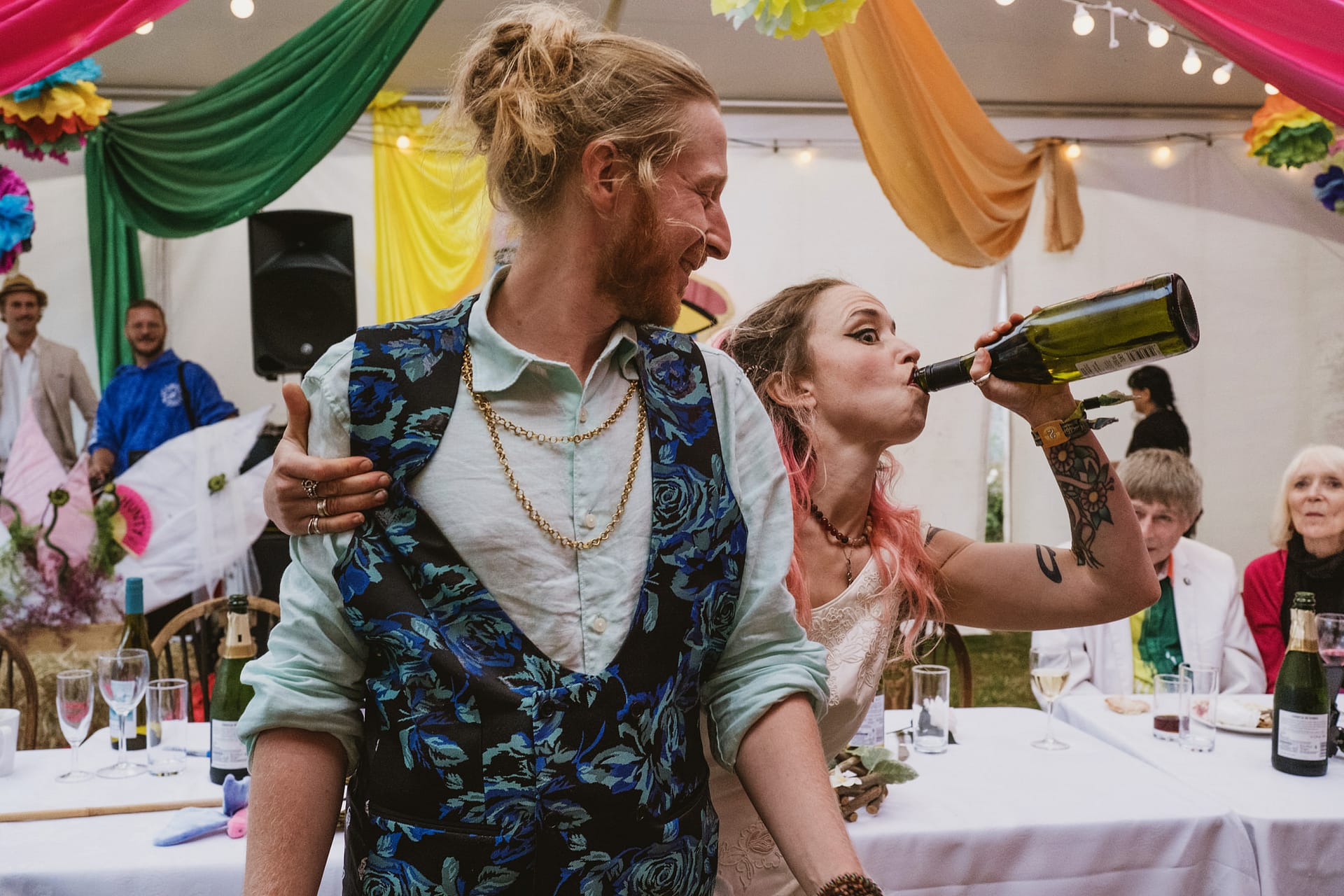 Couple celebrating at vibrant wedding reception.