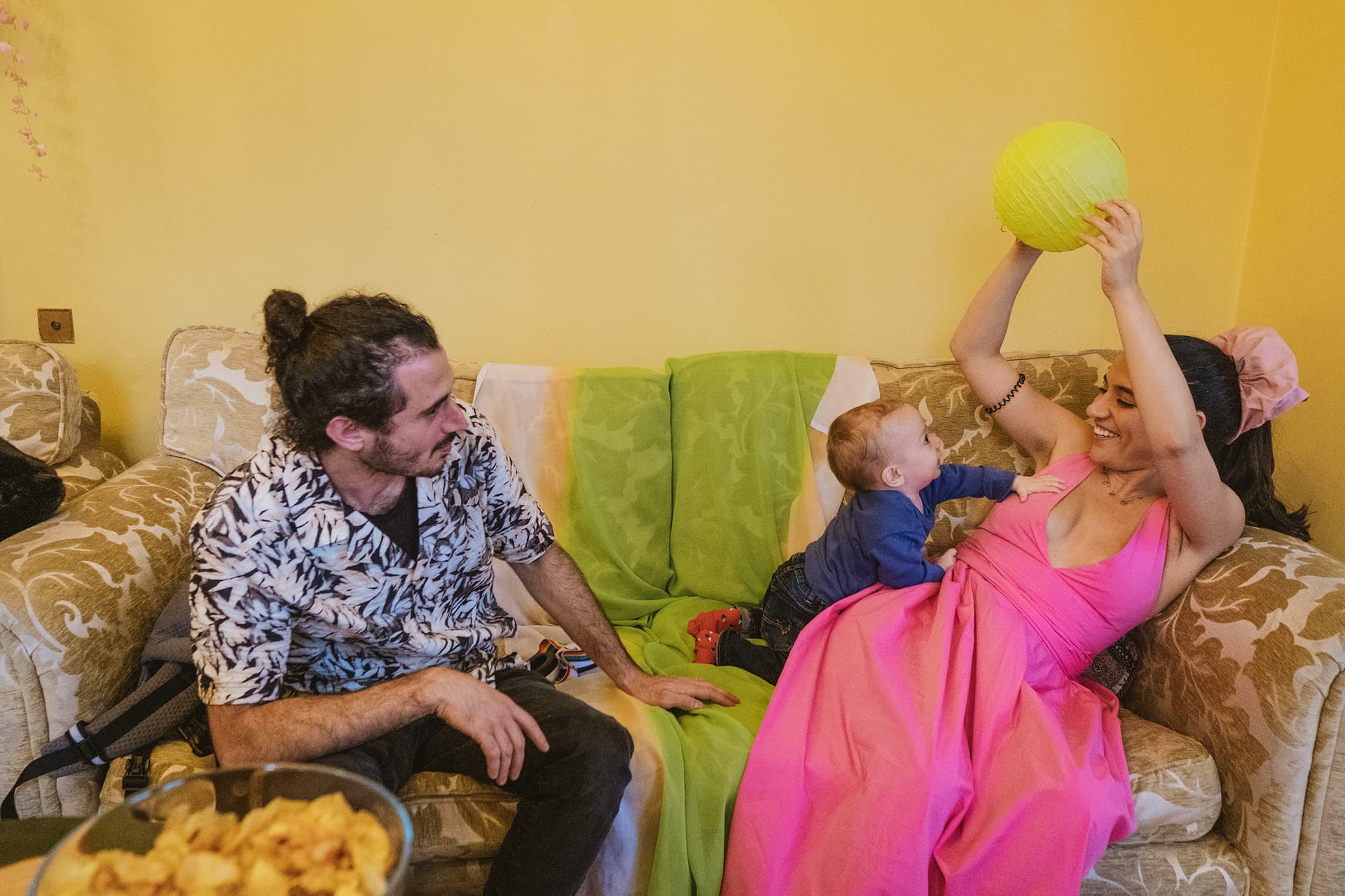 Family playing with baby on sofa