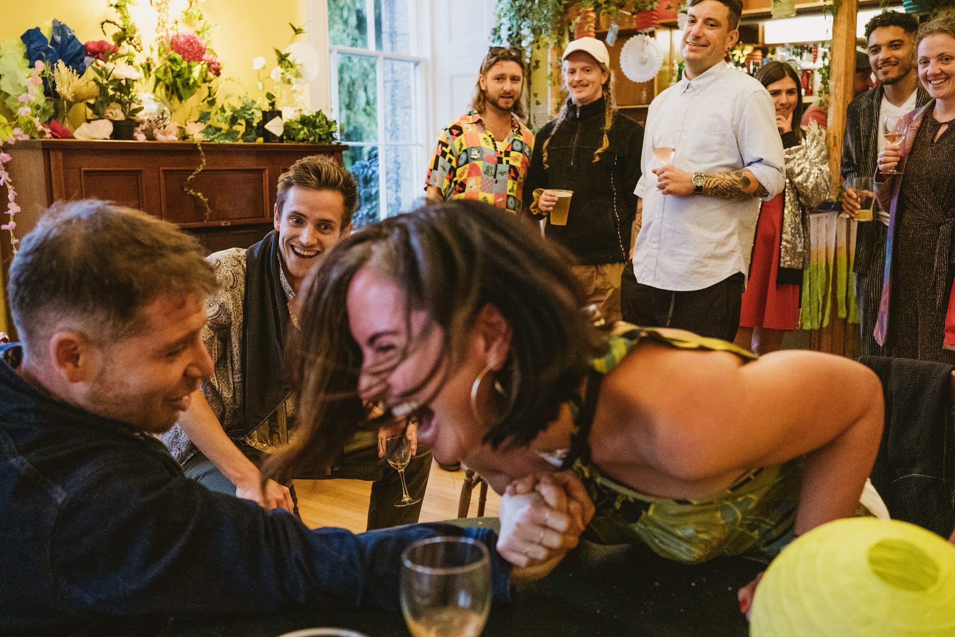 People enjoying arm wrestling at a lively gathering.