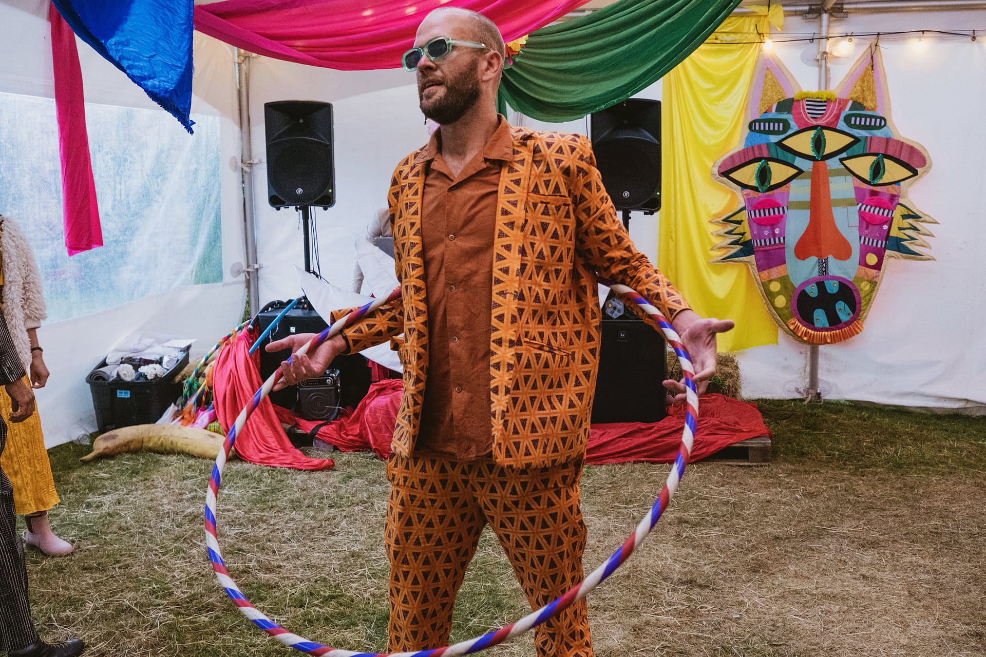 Man with hula hoop in colourful tent