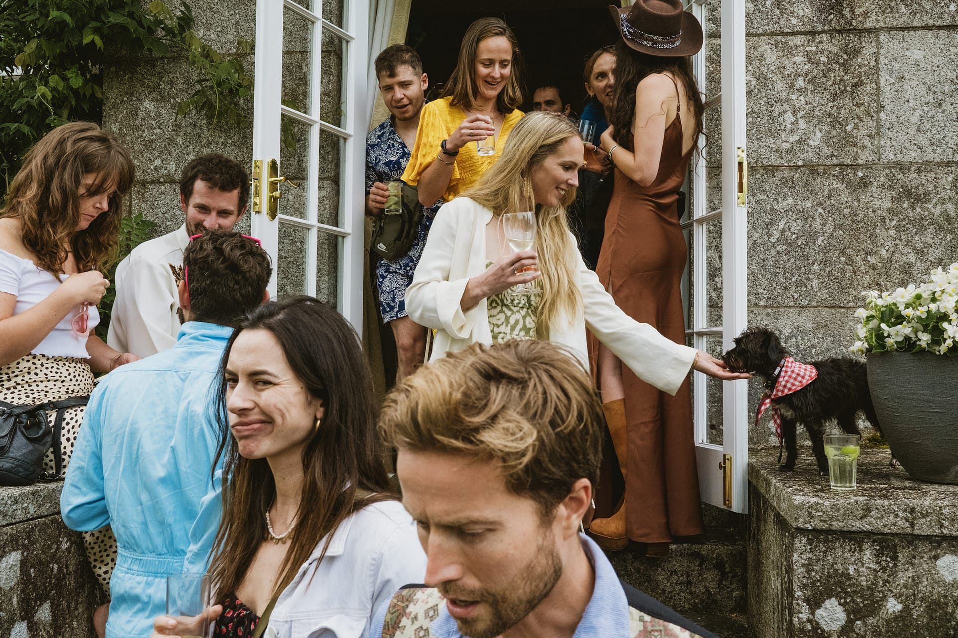 People at a party with drinks and a dog.