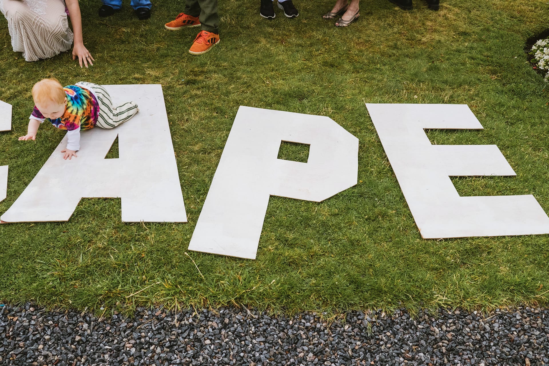 Baby crawling on large letters on grass