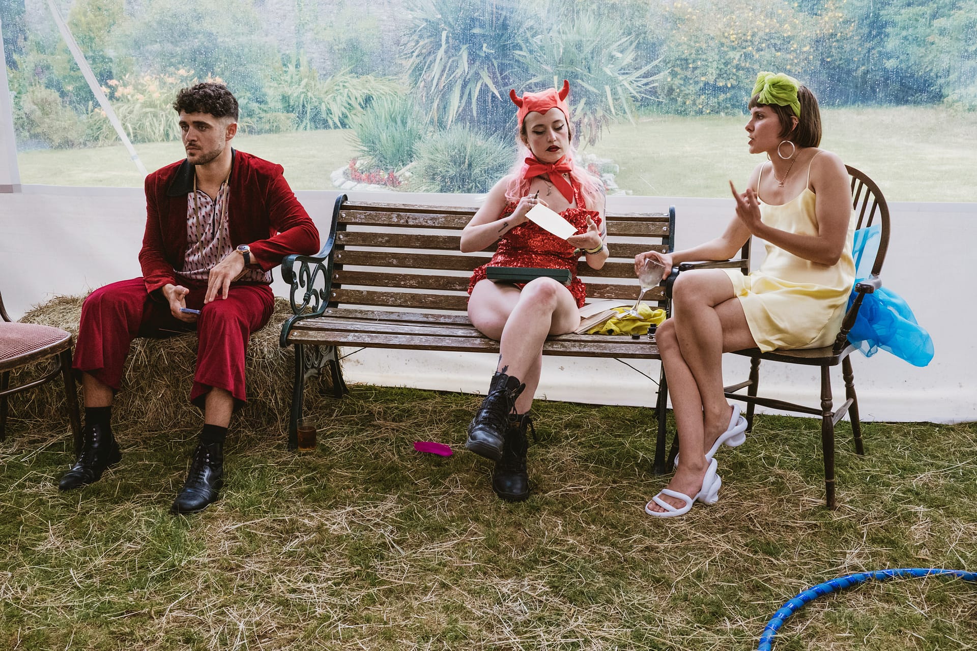 Three people in costumes seated on chairs.