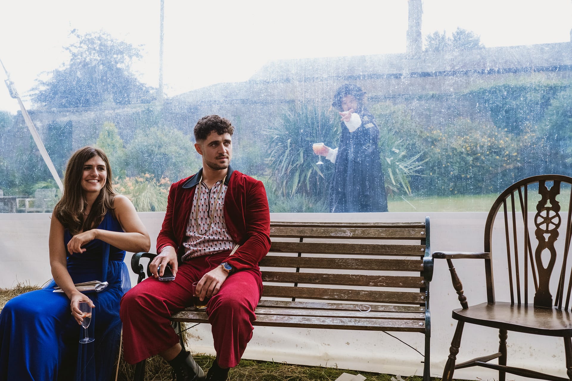 Couple sitting on a bench at an outdoor event.
