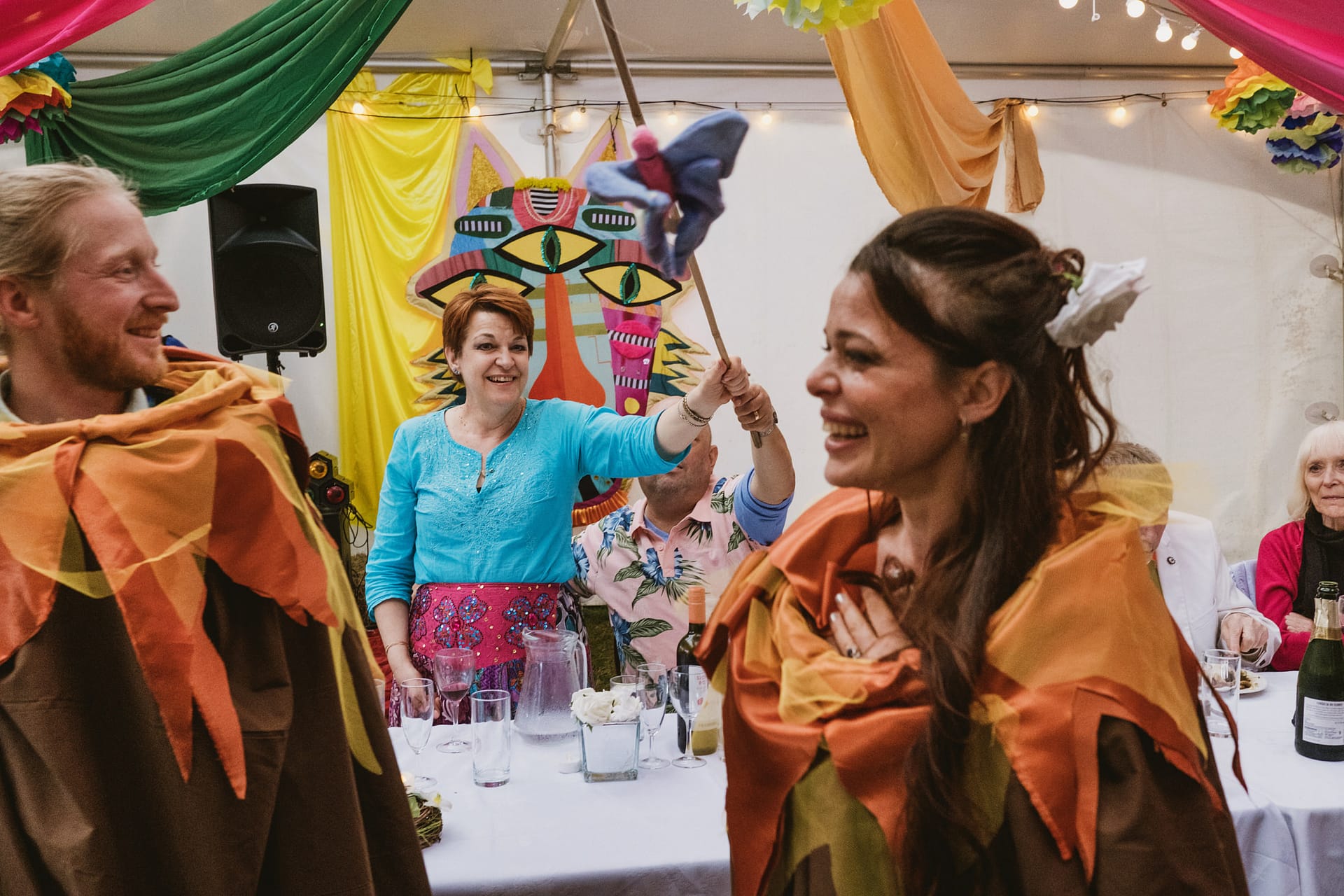 People in colourful costumes at a lively indoor event.