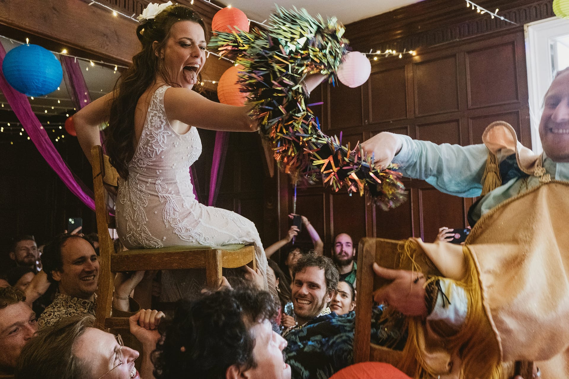 Bride lifted on chair during wedding celebration