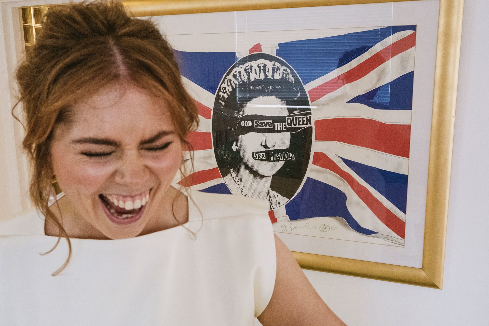Woman laughing before God Save The Queen artwork.