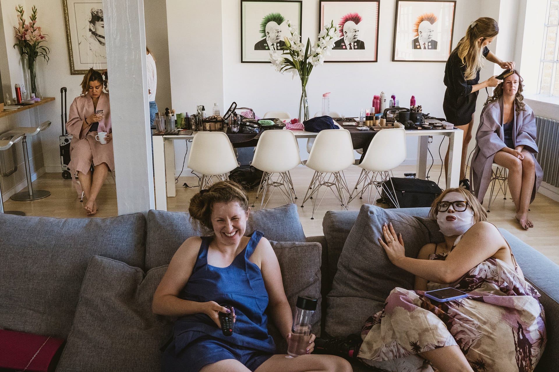 Women relaxing, preparing for an event in a room.