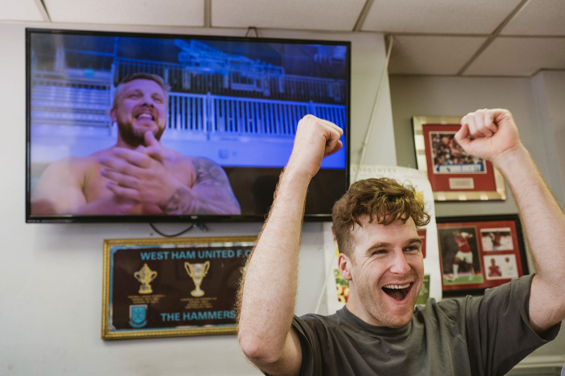Man cheering in front of TV screen