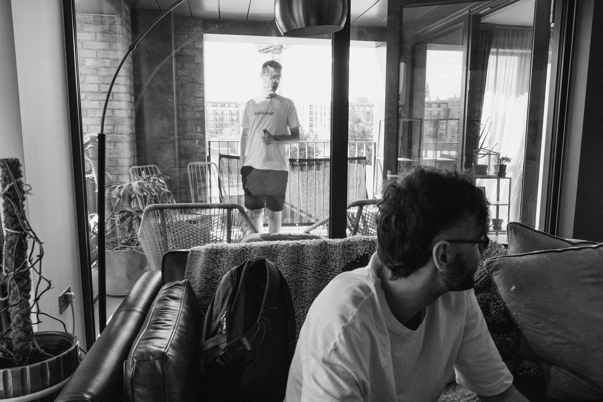 People relaxing in a modern apartment with balcony.