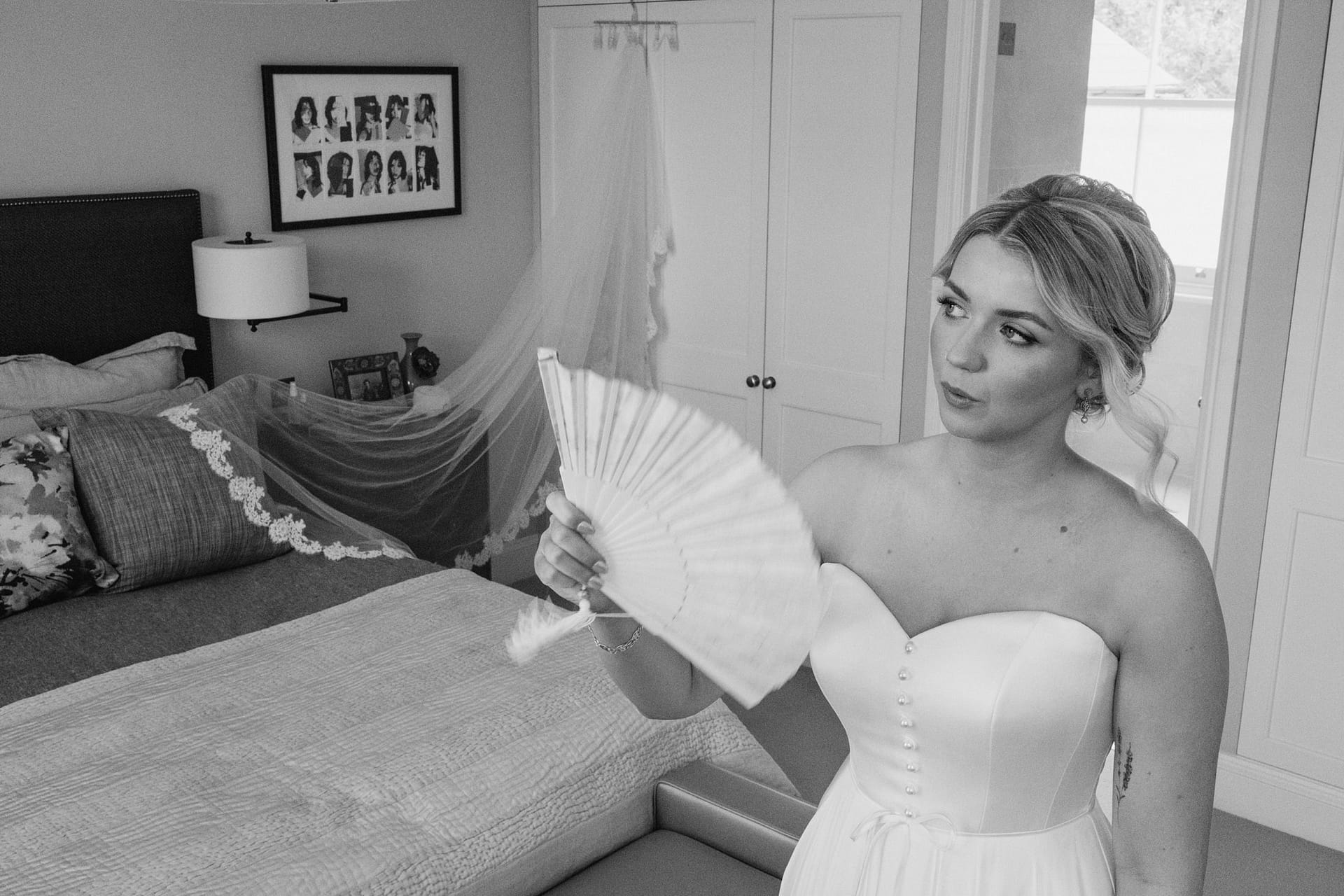 Bride with fan in bedroom before wedding.