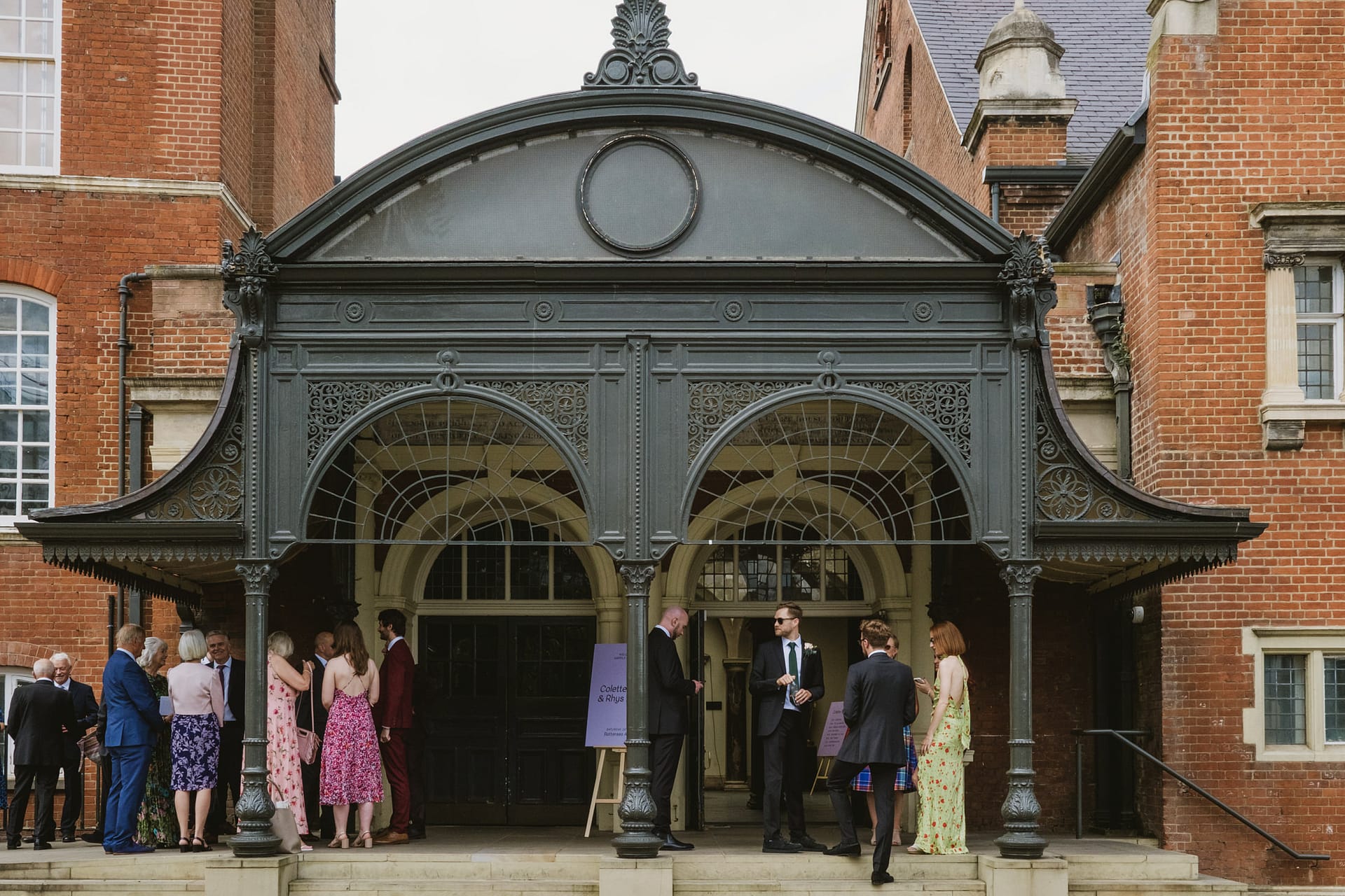 People outside historic building entrance.