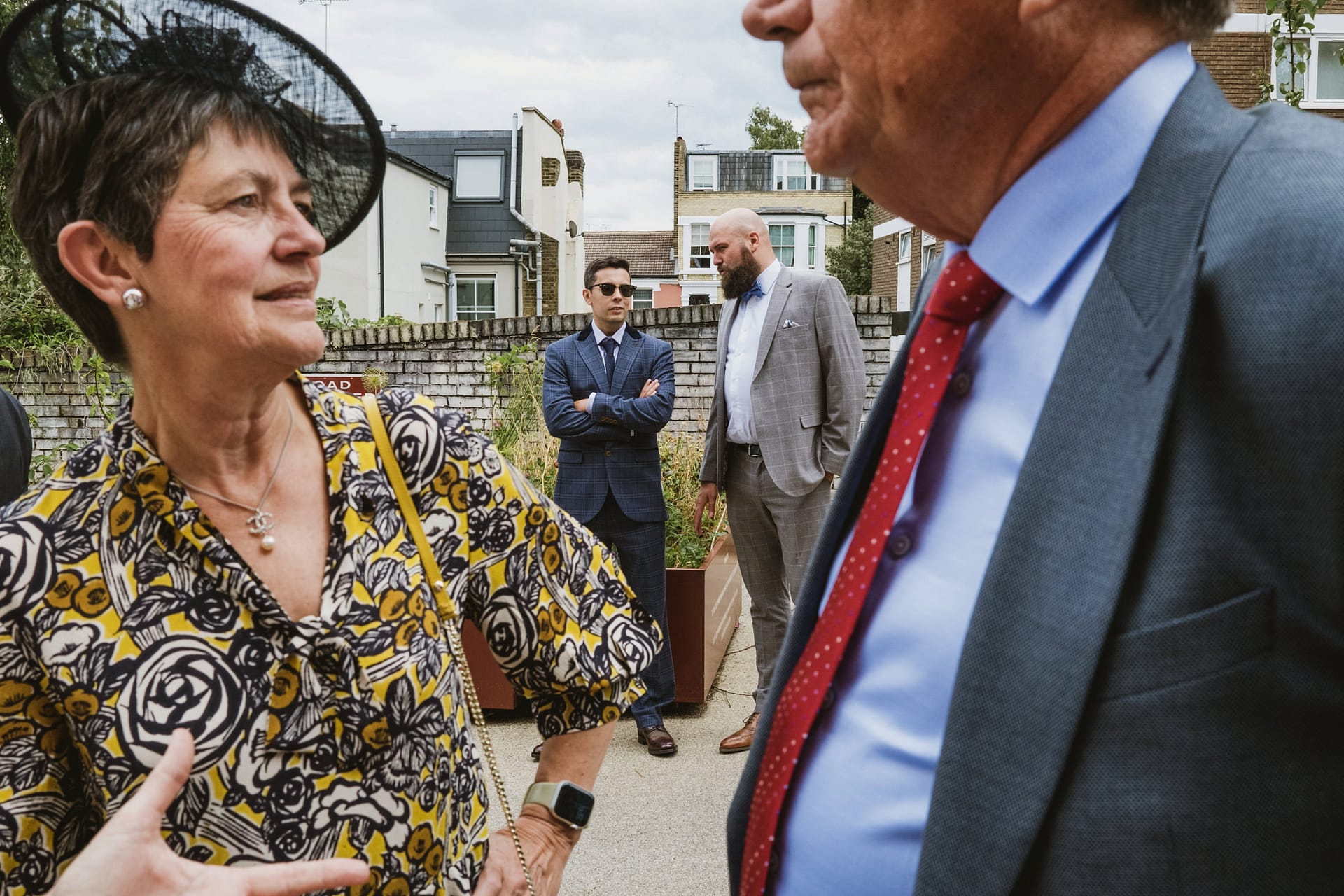 People socialising outdoors in formal attire.