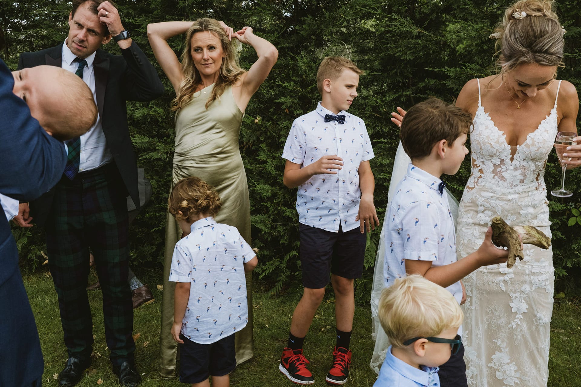 Family at outdoor wedding with kids in matching outfits.