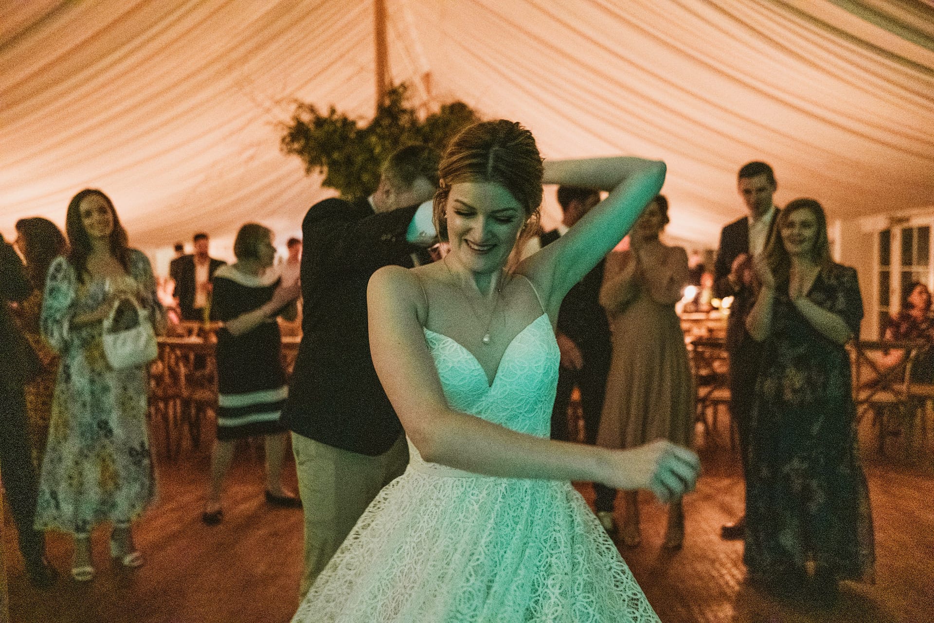 Bride dancing at indoor wedding celebration.