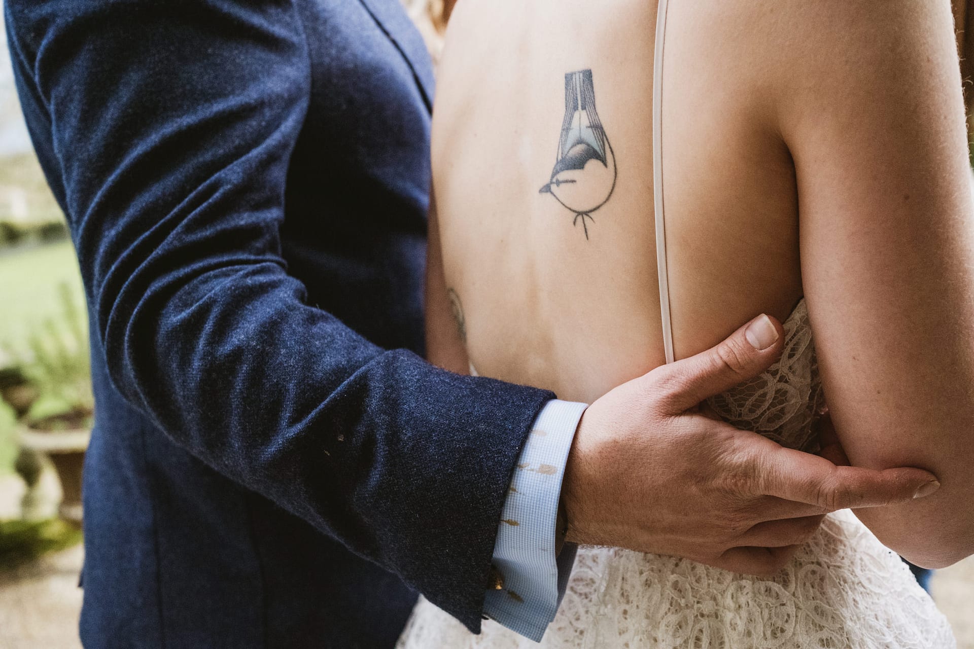 Back view of wedding couple with bird tattoo.