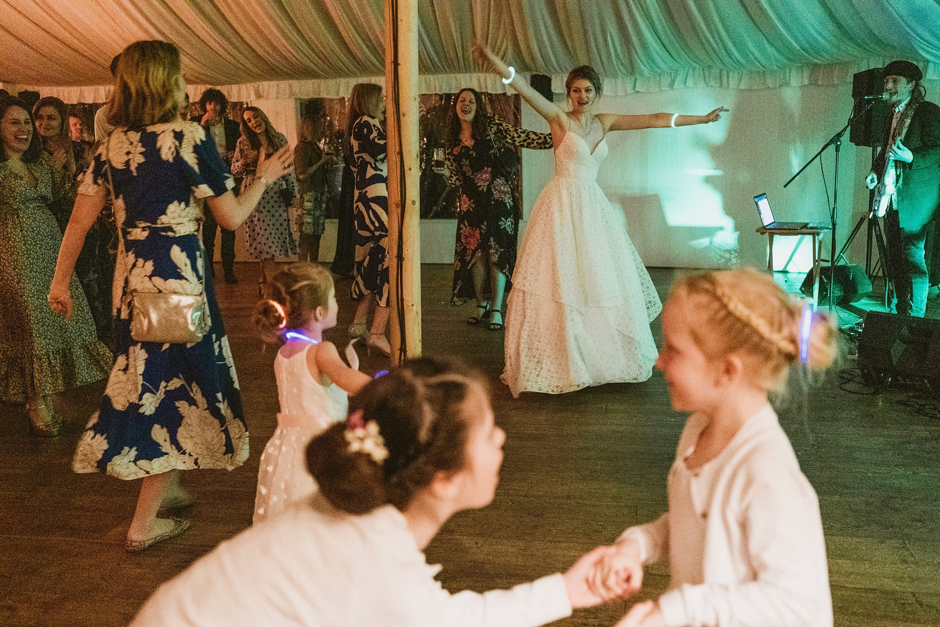 Wedding celebration with dancing guests and bride.