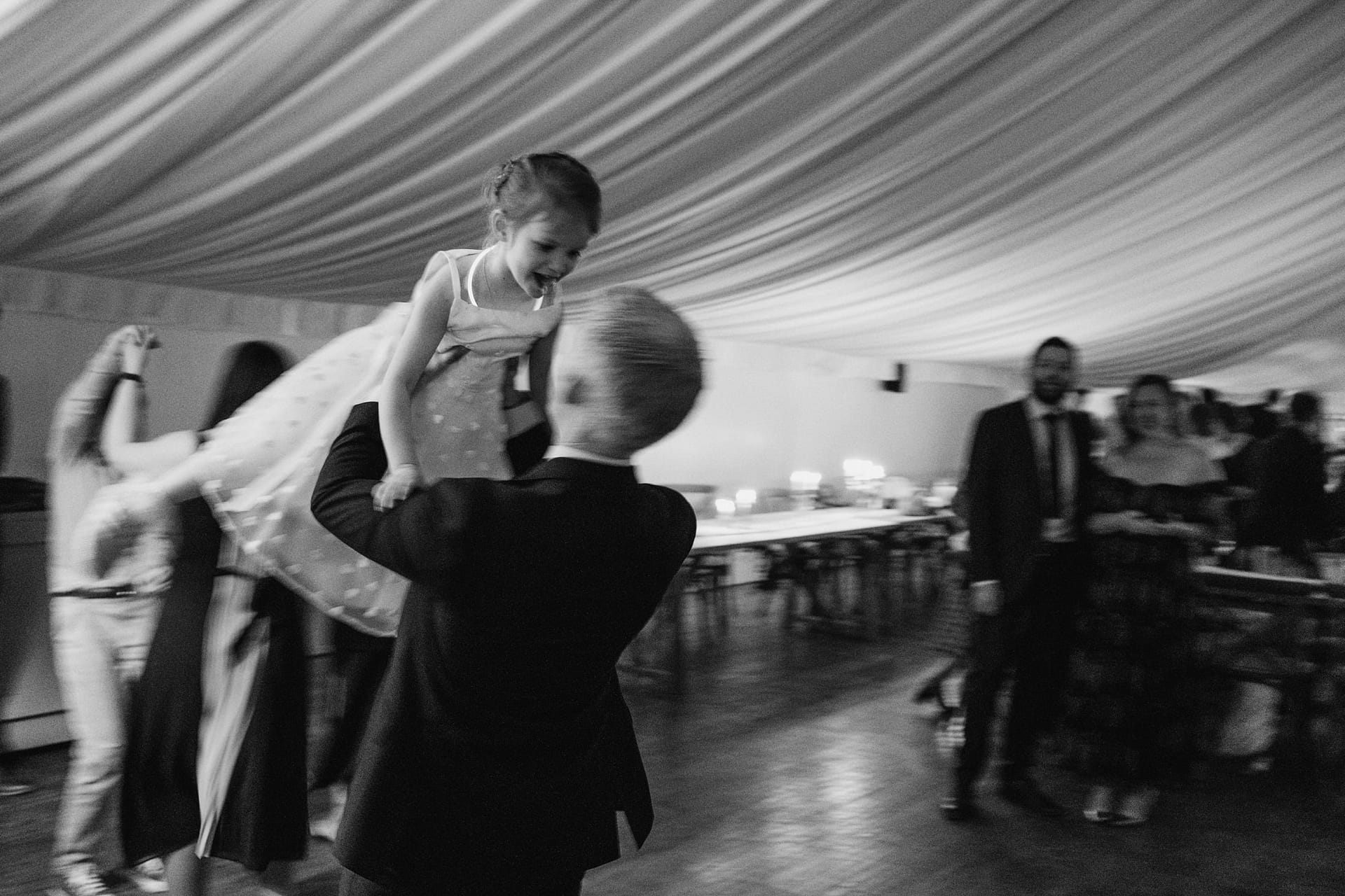 Man lifting girl in joyful dance at party.