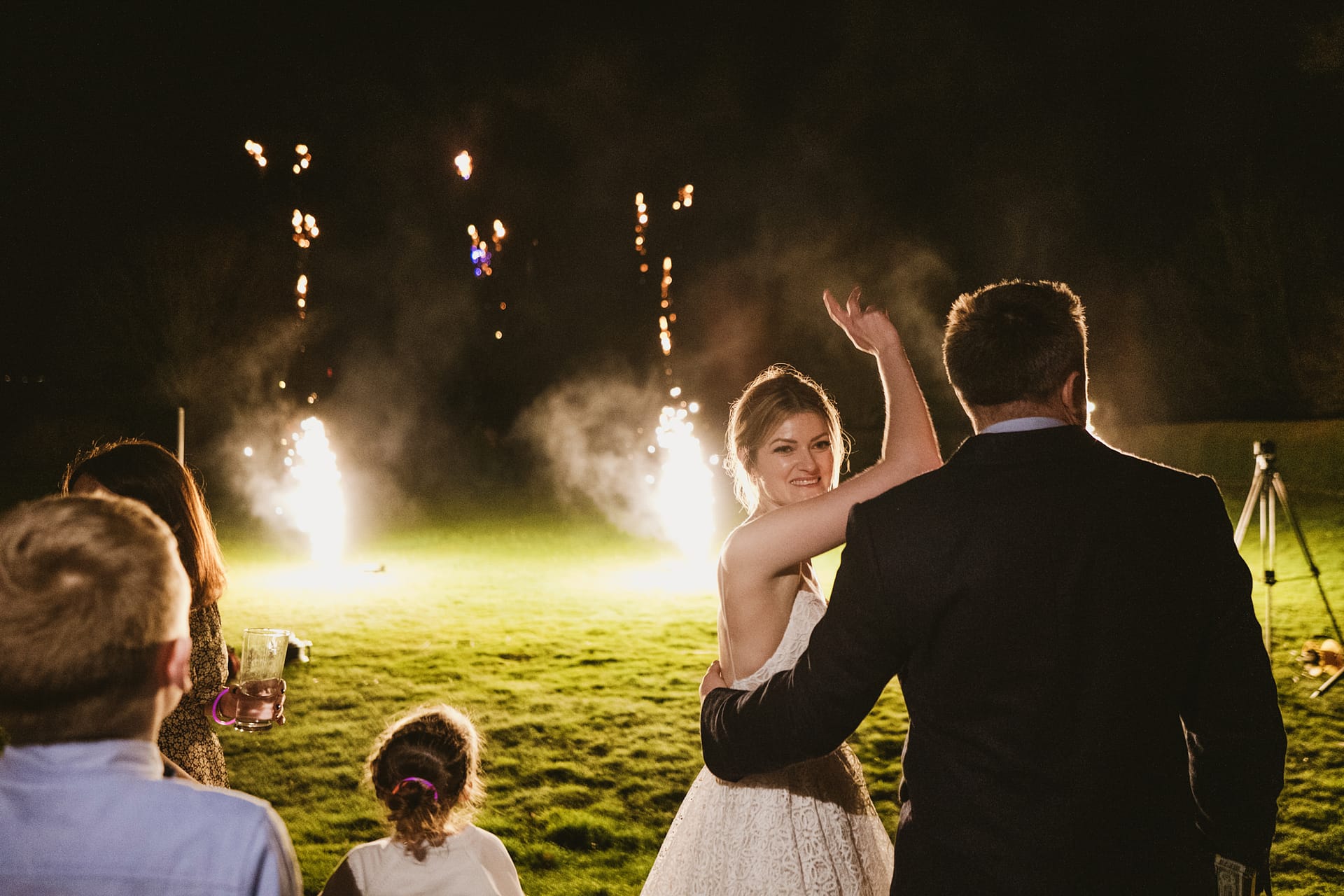 Couple watching fireworks at night wedding celebration.