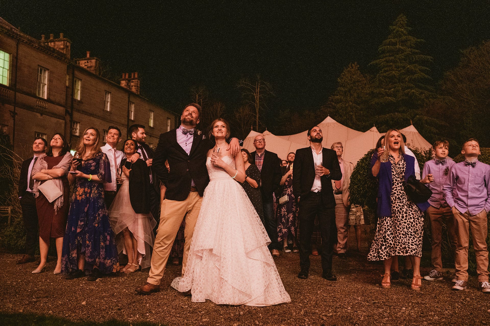 Guests enjoying outdoor wedding celebration at night.
