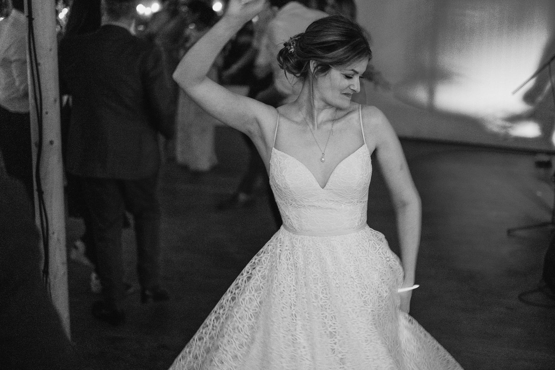 Bride joyfully dancing at wedding reception.