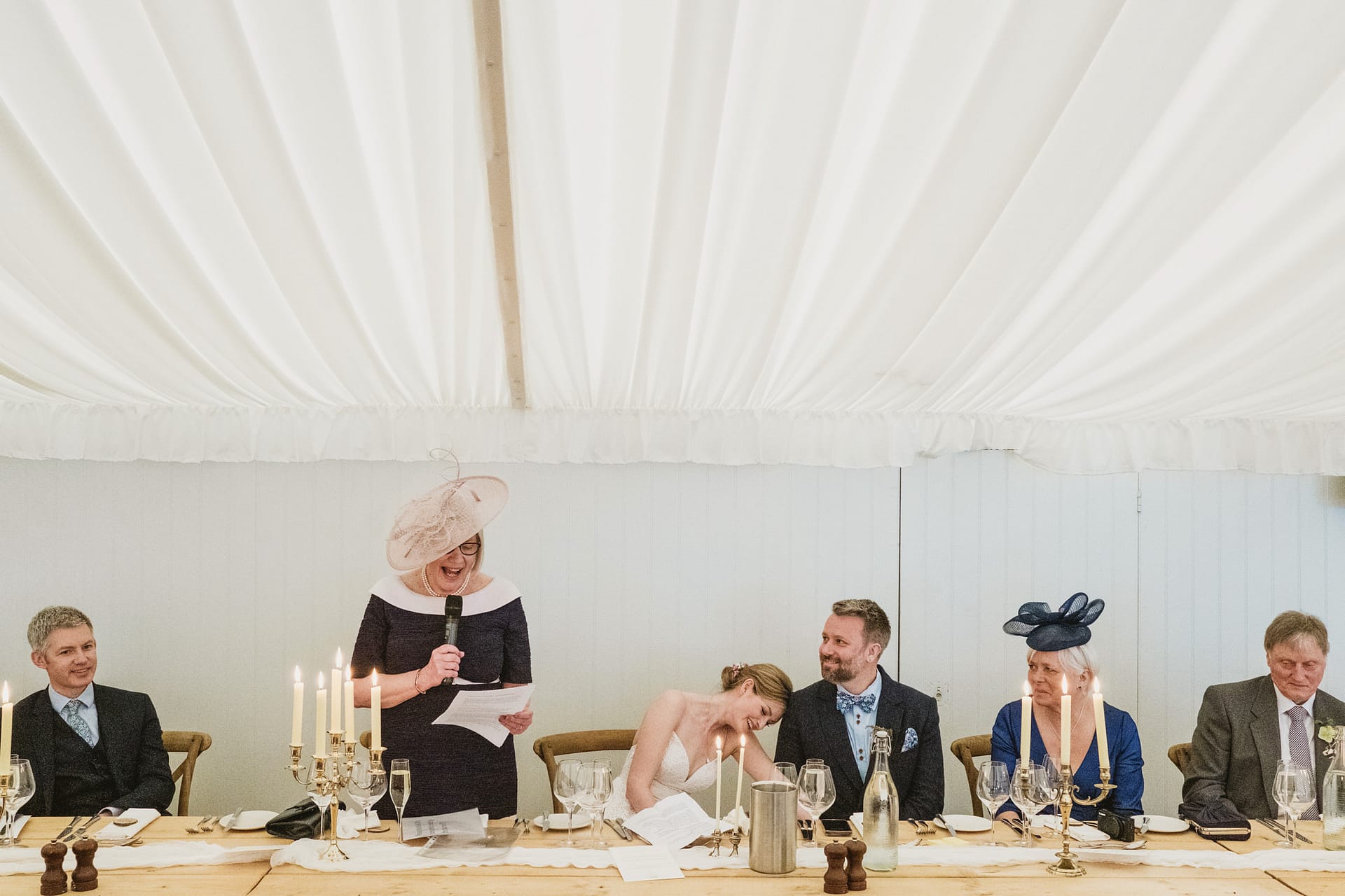 Wedding reception speech under marquee tent.
