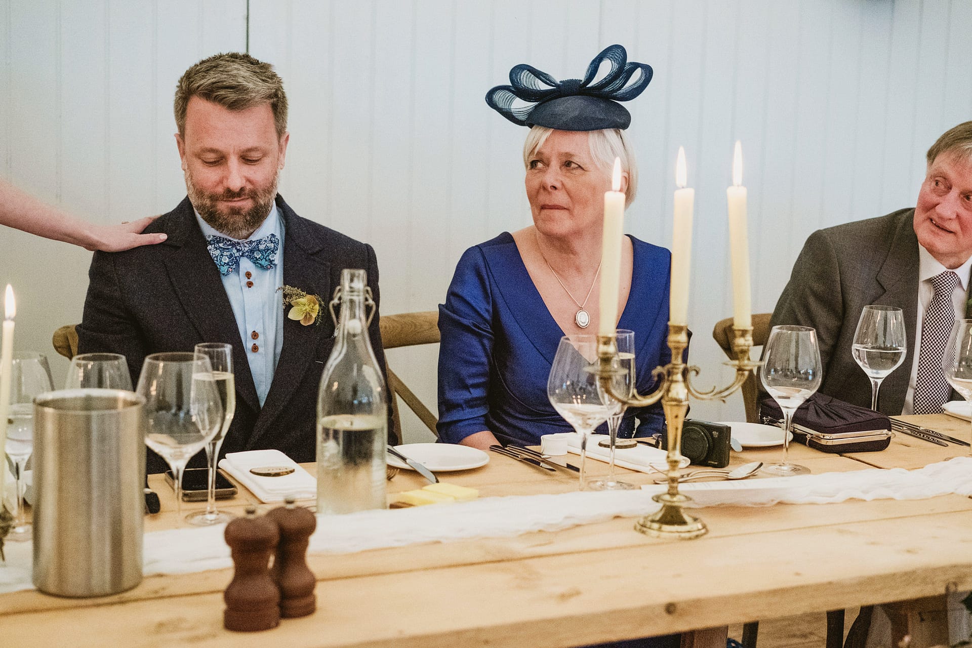 Guests seated at wedding table with decor.