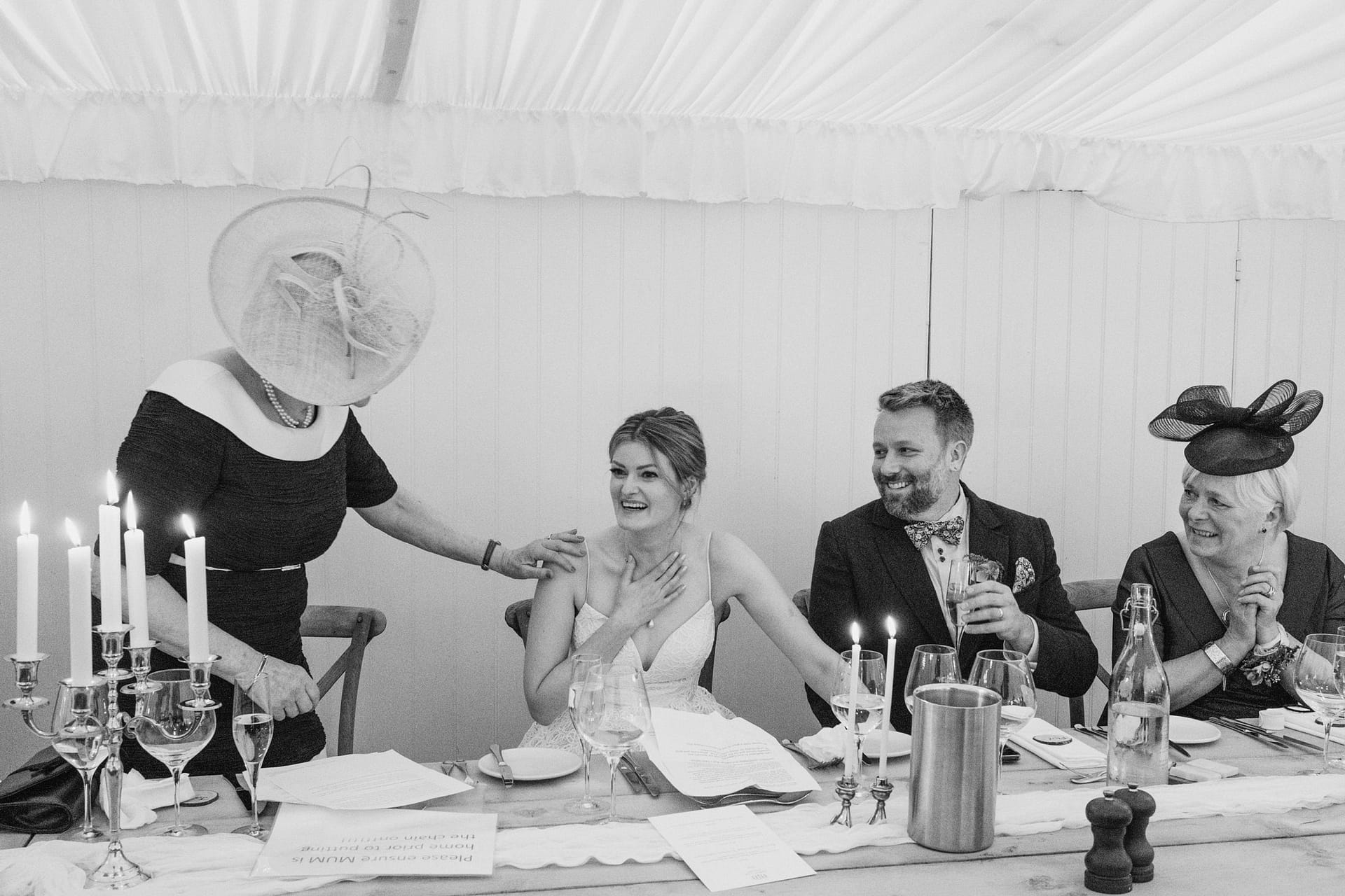 Black and white wedding reception with joyful guests.