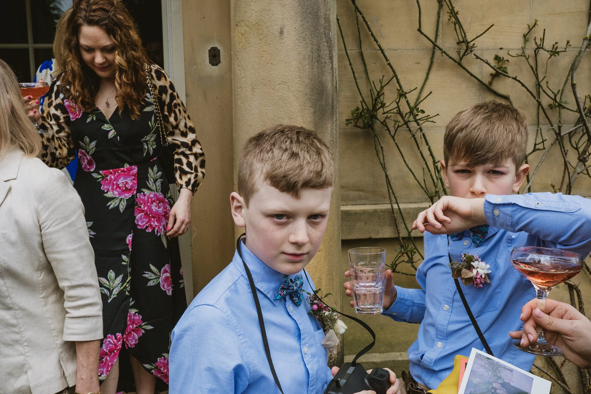 Children in blue shirts holding drinks at event.