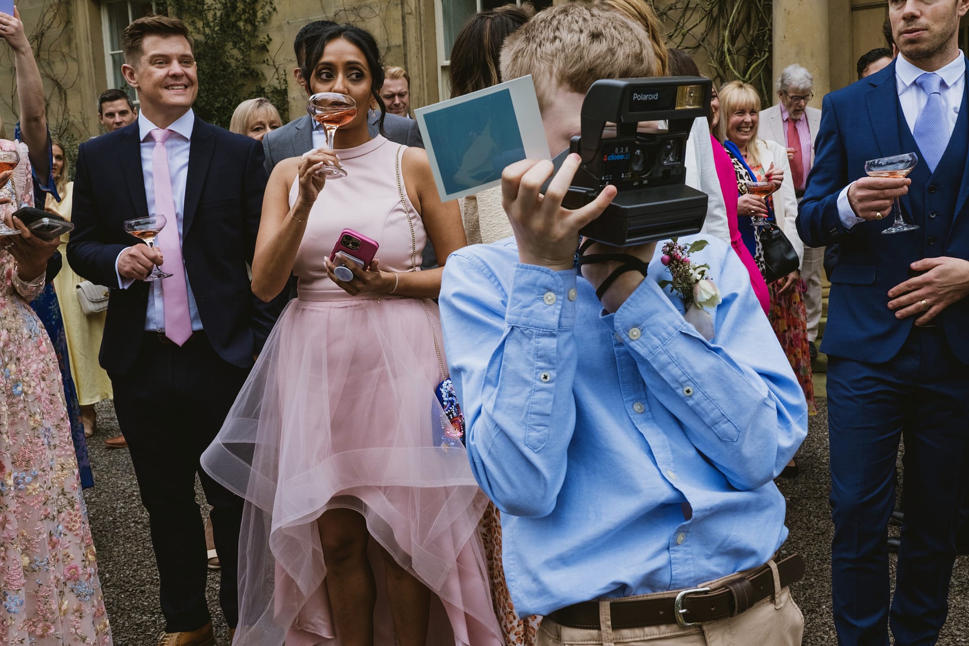 Guests at wedding with instant camera.