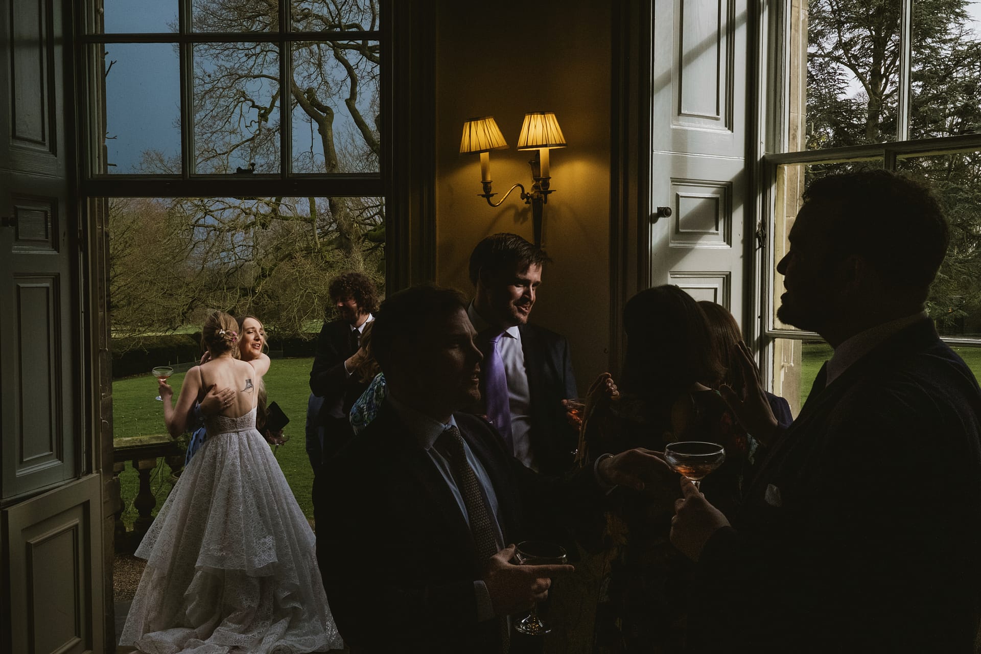 Wedding guests mingling at elegant indoor-outdoor event.