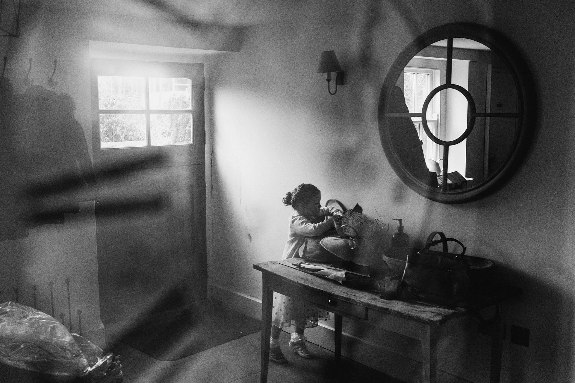 Child exploring items on a wooden table.