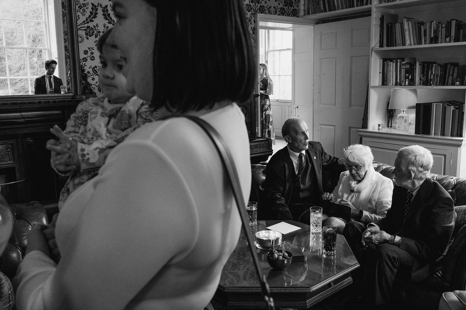 Group conversing in elegantly decorated room.