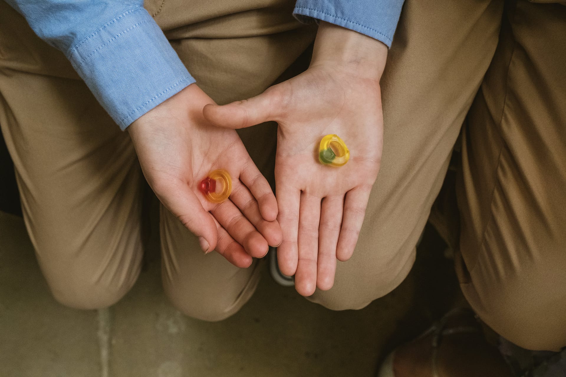 Hands holding two colourful sweet rings
