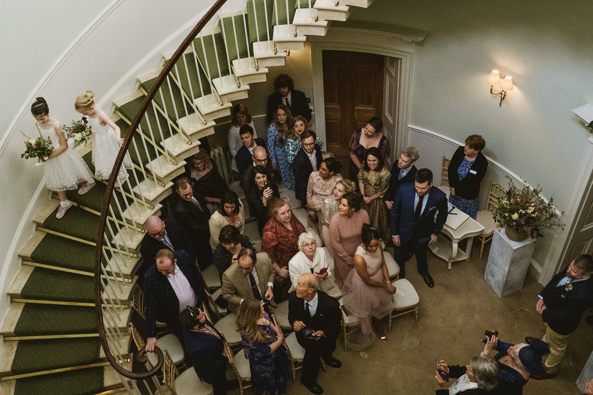 Wedding guests gathered in spiral staircase lobby.