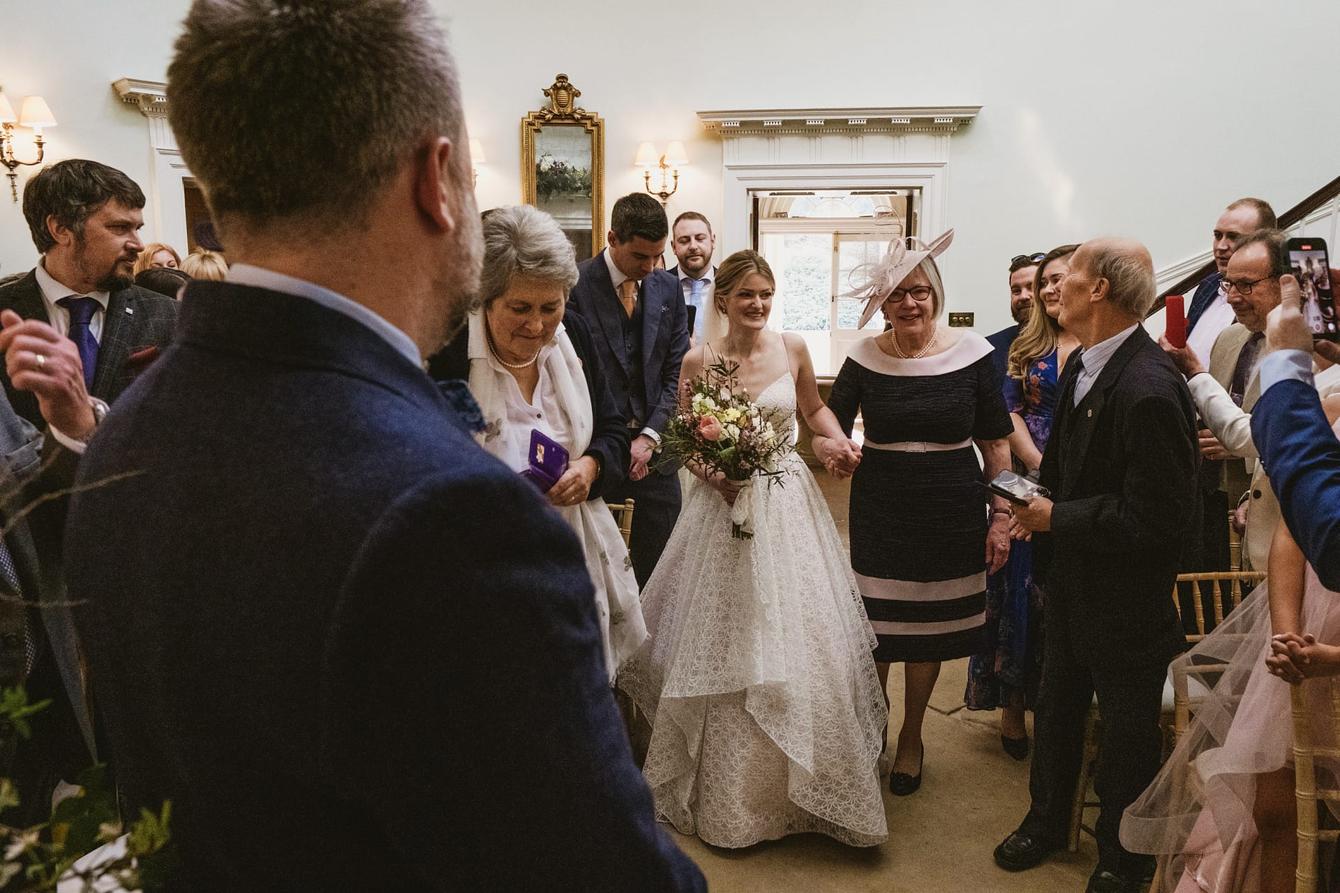 Bride walks down aisle with family and friends.