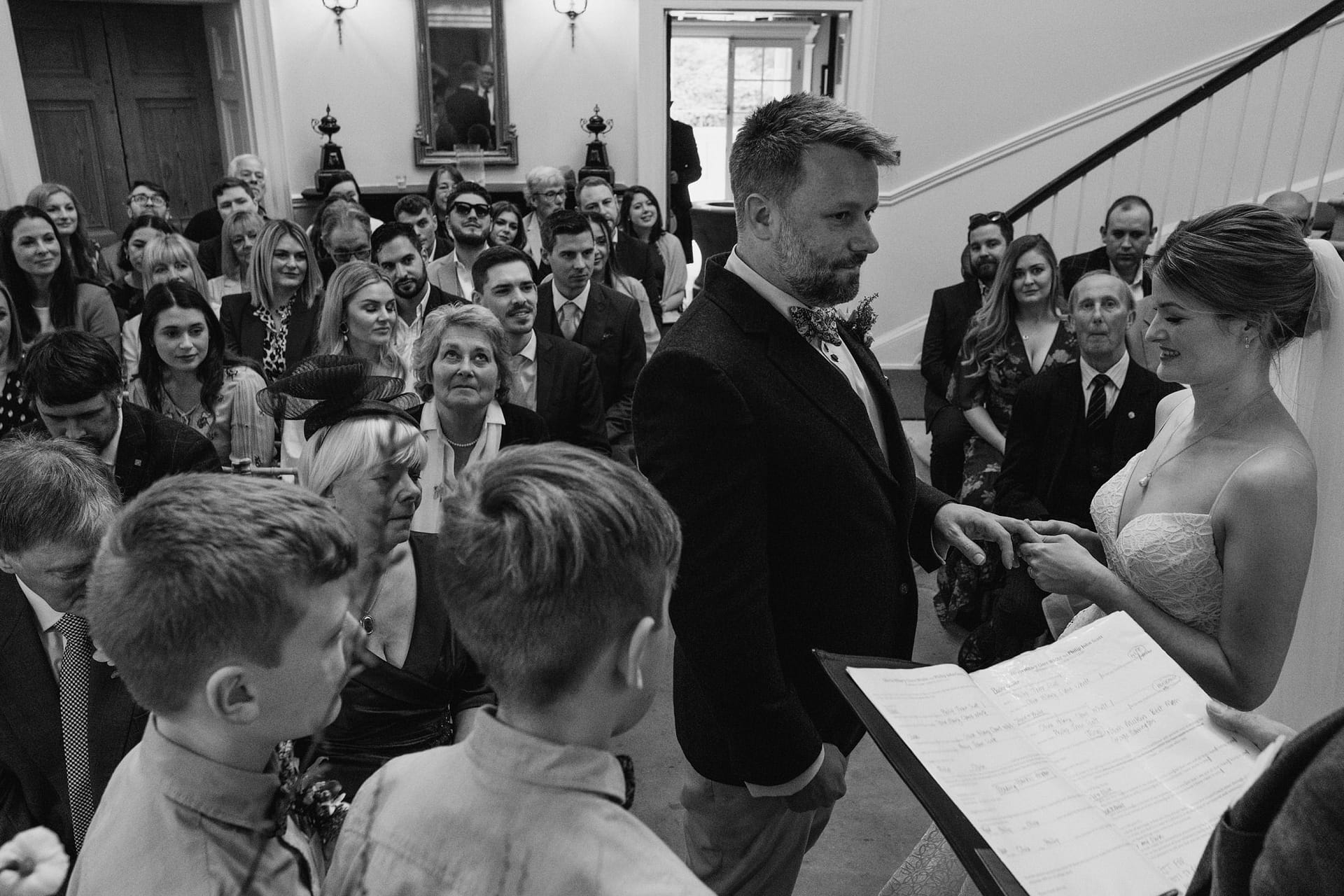 Bride and groom exchanging rings at wedding ceremony.