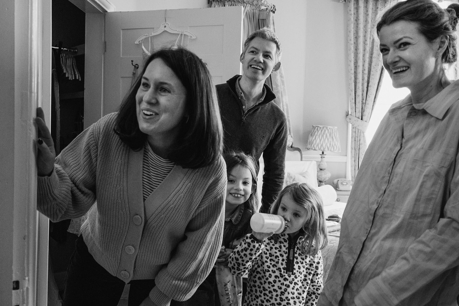 Family smiling together indoors, enjoying a moment.
